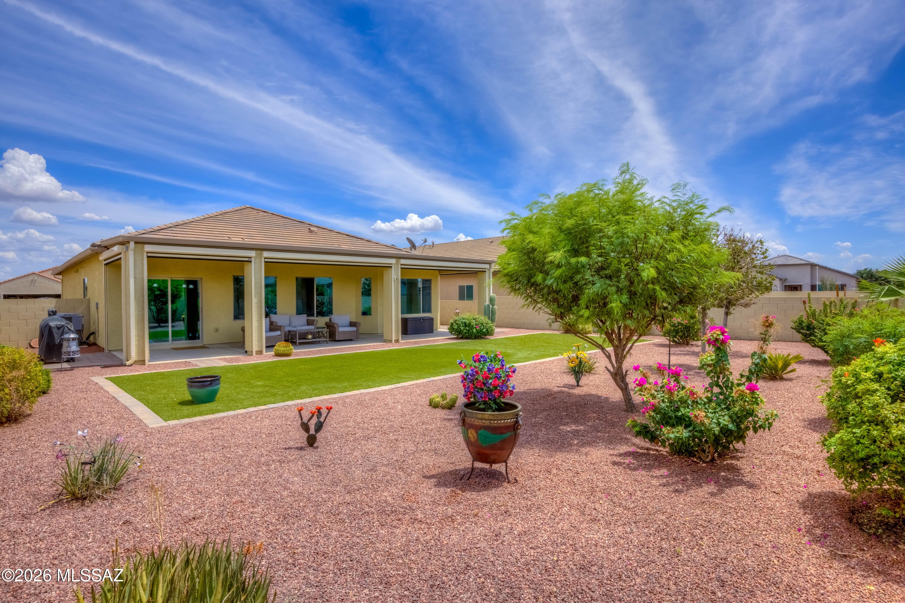 This beautiful Red Rock home is better than brand new! Come see this well maintained and upgraded home with 3 bedrooms and 2 full baths in a split bedroom floor plan. An inviting open kitchen with granite countertops and stainless appliances looks over the great room and dining area, with views out to the backyard. The spacious backyard has been professionally landscaped with artificial turf, drip irrigation, pavers and lush foliage. Custom remote controlled shades will turn the patio into a shady retreat for year round enjoyment. Inside, the primary suite has large bay windows, a walk-in closet and dual vanities. The two additional bedrooms are comfortable and joined by the guest full bath and a laundry room. Don't miss the owned solar system for big energy savings. Come see it today!