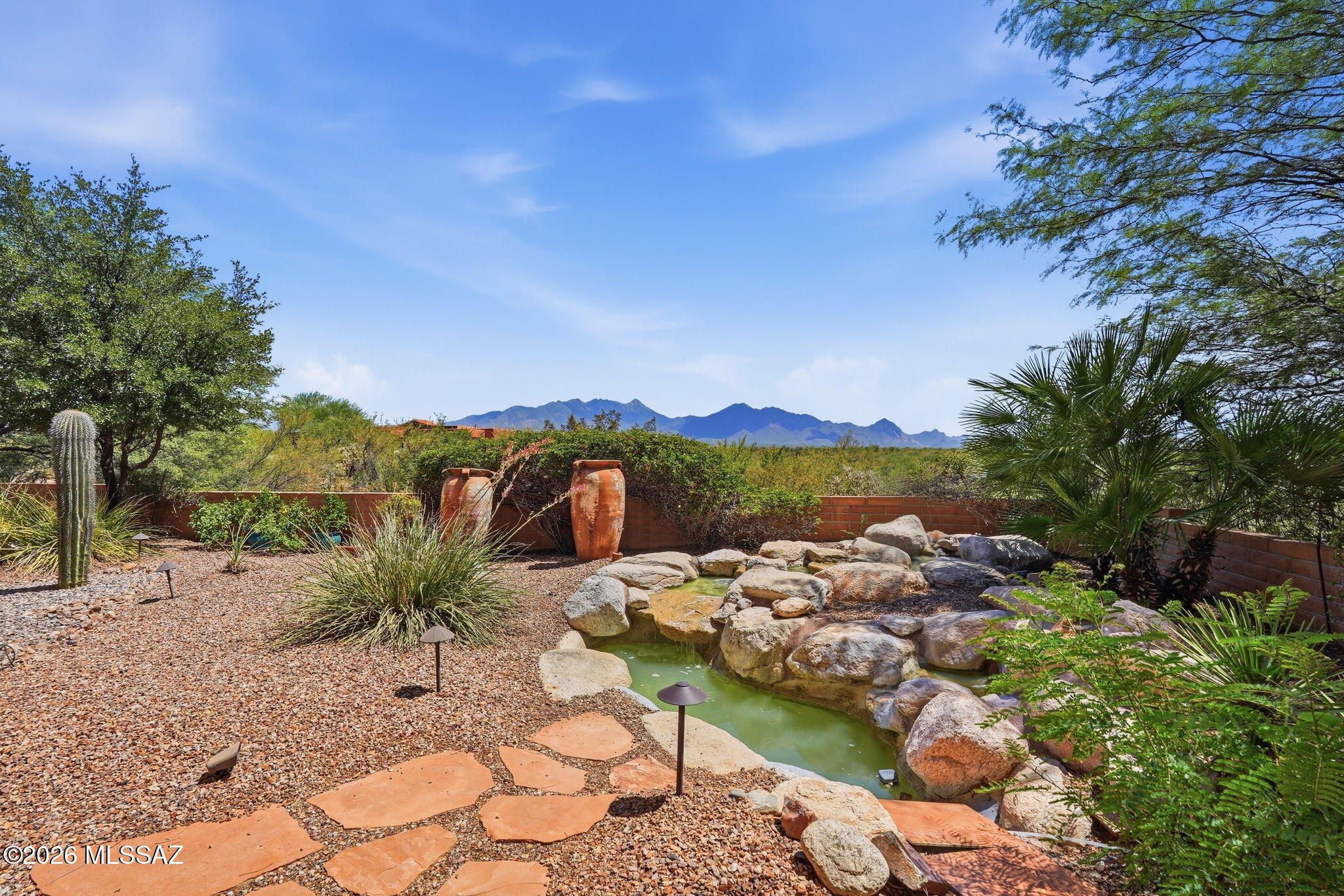 Welcome to your private Southern Arizona retreat, beautifully situated at the end of a quiet cul-de-sac on 2.08 acres within a gated community offering breathtaking views of the Santa Rita Mountains, including Mount Wrightson and Mount Hopkins. This spacious home combines privacy, comfort, and versatility with an open floor plan, high ceilings, abundant natural light, a gas fireplace, whole-house surround sound, and beautiful wood-framed Andersen windows with removable solar screens. The chef-inspired kitchen features high-end granite countertops, gorgeous cabinetry, modern appliances, a gas cooktop, center island, pantry, and a bright breakfast nook overlooking the surrounding scenery, while a separate dining room provides plenty of space for larger gatherings. The generous primary suite feels like a private resort with plush carpeting, its own gas fireplace, a spacious bathroom with dual vanities, Toto toilet, garden tub, separate shower, and a large walk-in closet with an organizational system. Flexible rooms provide options for a media room, office, additional bedrooms, hobbies, or whatever best suits your lifestyle. Outside is where this property truly shines, with mature manicured landscaping, a soothing water feature, an enclosed backyard, and an impressive covered porch featuring a three-year-old built-in BBQ and Artisan mini refrigerator--all overlooking the spectacular mountain scenery. Three extended garage spaces include epoxy-coated floors, mini-split, and premium Baldhead cabinets with a worktop, while a dedicated RV area with hookups adds even more convenience. With the roof completely recoated two years ago, recently painted exterior, three-year-old HVAC system, nearby shopping and restaurants, abundant wildlife, and incredible indoor and outdoor living spaces, this property offers the privacy of acreage living with the comfort and conveniences that make every day feel like a retreat.