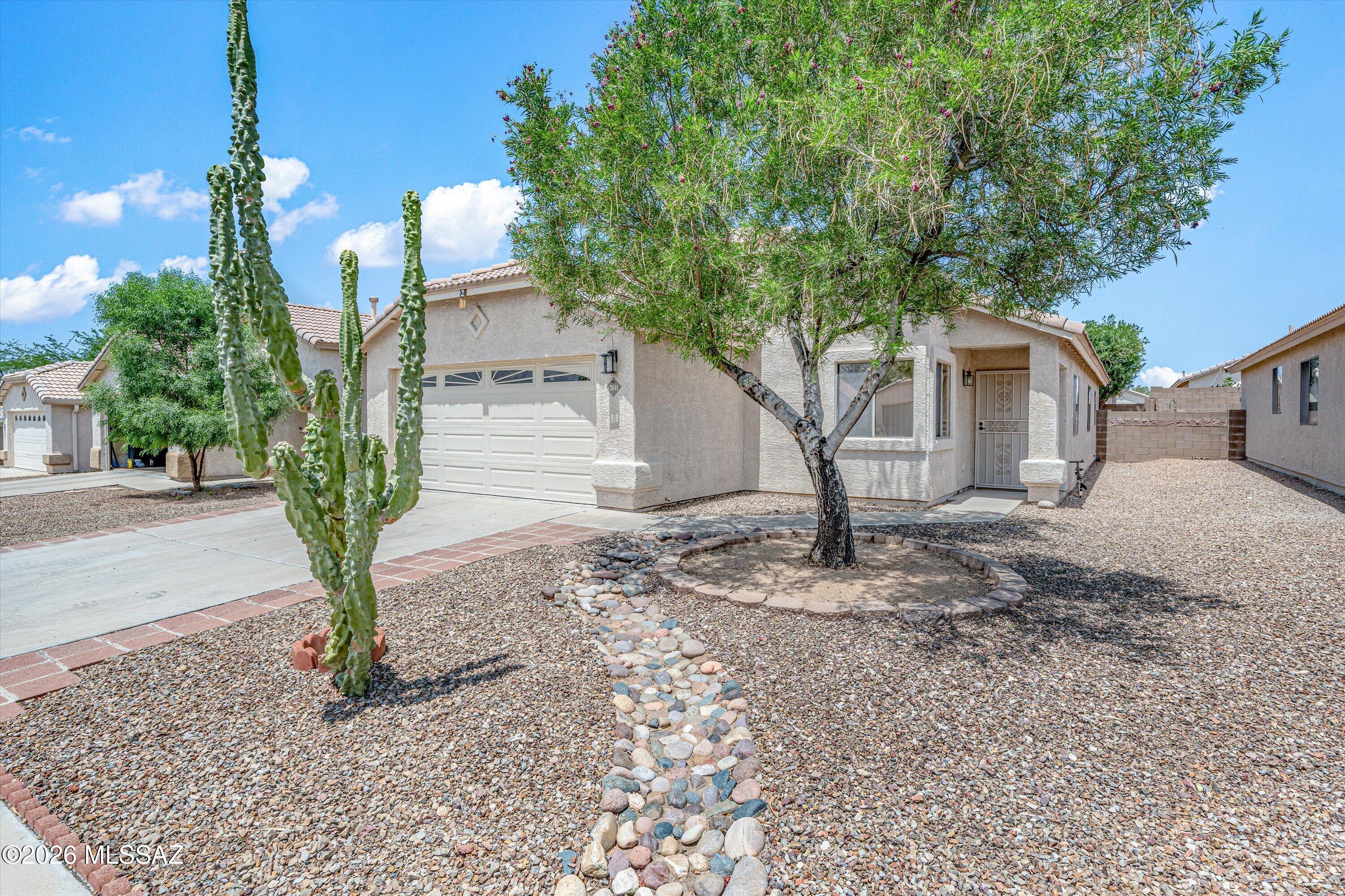 Beautiful 4BR/2 BA home in the gated community of Mona Lisa! This well-maintained home features tile flooring throughout, a spacious living/dining room with gas fireplace, and a desirable split-bedroom floor plan. The kitchen offers stainless steel appliances, gas range, refrigerator,  lots of cabinets, pantry, breakfast bar island, and opens to a comfortable family room. The generous primary suite includes a large Walk-In closet, and bath with a Walk-In shower. Garage has a 4 ft extension for larger cars or storage. Enjoy the outdoor living space in the low-care backyard with covered patio, extended flagstone patio, and raised planter area. The home is conveniently located near Pima Community College, the YMCA, shopping, dining, and Foothills Mall. This is a wonderful place to call home!