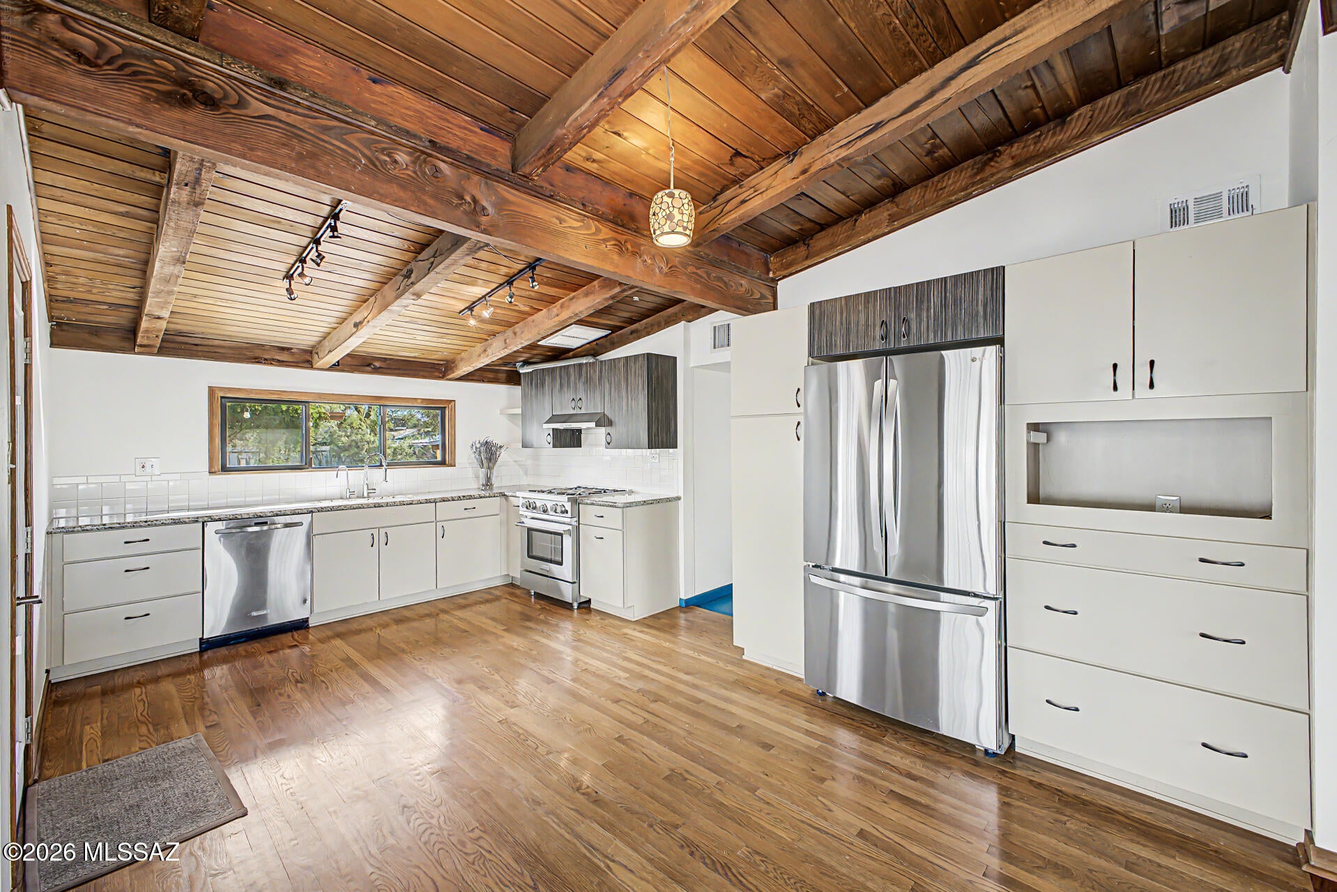 Discover your own private sanctuary in the heart of Midtown! This charming home welcomes you with a spacious covered front porch. Inside, the warm and inviting great room features beautiful oak floors, soaring vaulted ceilings with exposed beams, and rich wood-paneled walls. The updated kitchen boasts granite countertops, soft-closing medallion cabinetry, while the flexible floor plan offers two generously sized front bedrooms and a smaller third bedroom or den. Other upgrades: Milgard windows, newer appliances, tankless water heater, new HVAC, and more.

Spacious, beautifully xeriscape yard featuring a diverse selection of native and desert-adapted plants plus two water harvesting tanks.