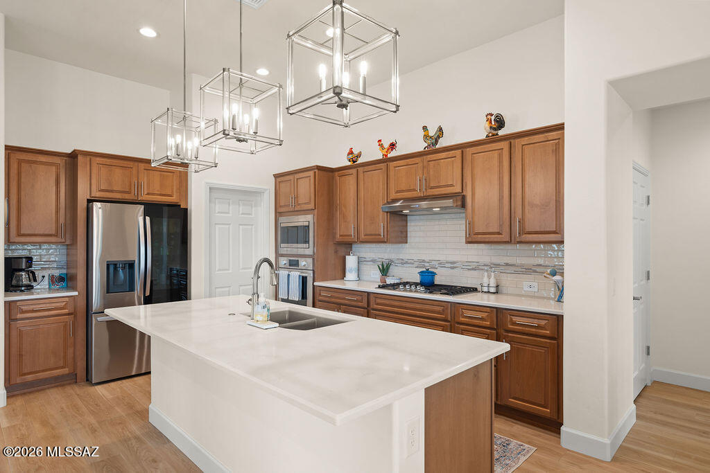 Welcome to luxury living in the highly sought-after 55+ community of Quail Creek. This stunning home showcases top-of-the-line upgrades throughout with no expense spared.

From the moment you step inside, you'll notice the attention to detail--plantation shutters, recessed lighting, luxury vinyl flooring, crown molding, high baseboards, and soaring 11-ft ceilings create an elegant and inviting atmosphere. The thoughtfully designed split floor plan offers privacy, with a luxurious primary suite featuring a beautifully tiled walk-in shower and custom closet system, while the guest bedroom enjoys its own private full bathroom with a tiled shower/tub combo.

At the heart of the home is a gorgeous, high-end kitchen complete with upgraded cabinetry, soft-close drawers, walk-in pantry, and premium finishes--perfect for both everyday living and entertaining. Just beyond, you'll find wall-to-wall built-in cabinetry with a wet bar and wine fridge, adding both function and sophistication.

Situated on a corner lot near the Canyon Club, this home offers peek-a-boo mountain views and a beautifully designed outdoor space featuring a covered patio, motorized shades, outdoor TV mount, and an extended paver patio--ideal for enjoying Arizona's stunning sunsets.

The epoxy-coated garage includes a water softener system, rounding out this meticulously upgraded home that truly has it all.

Enjoy resort-style amenities including golf, pools, fitness center, pickleball, and endless social activities--all part of the Quail Creek lifestyle.