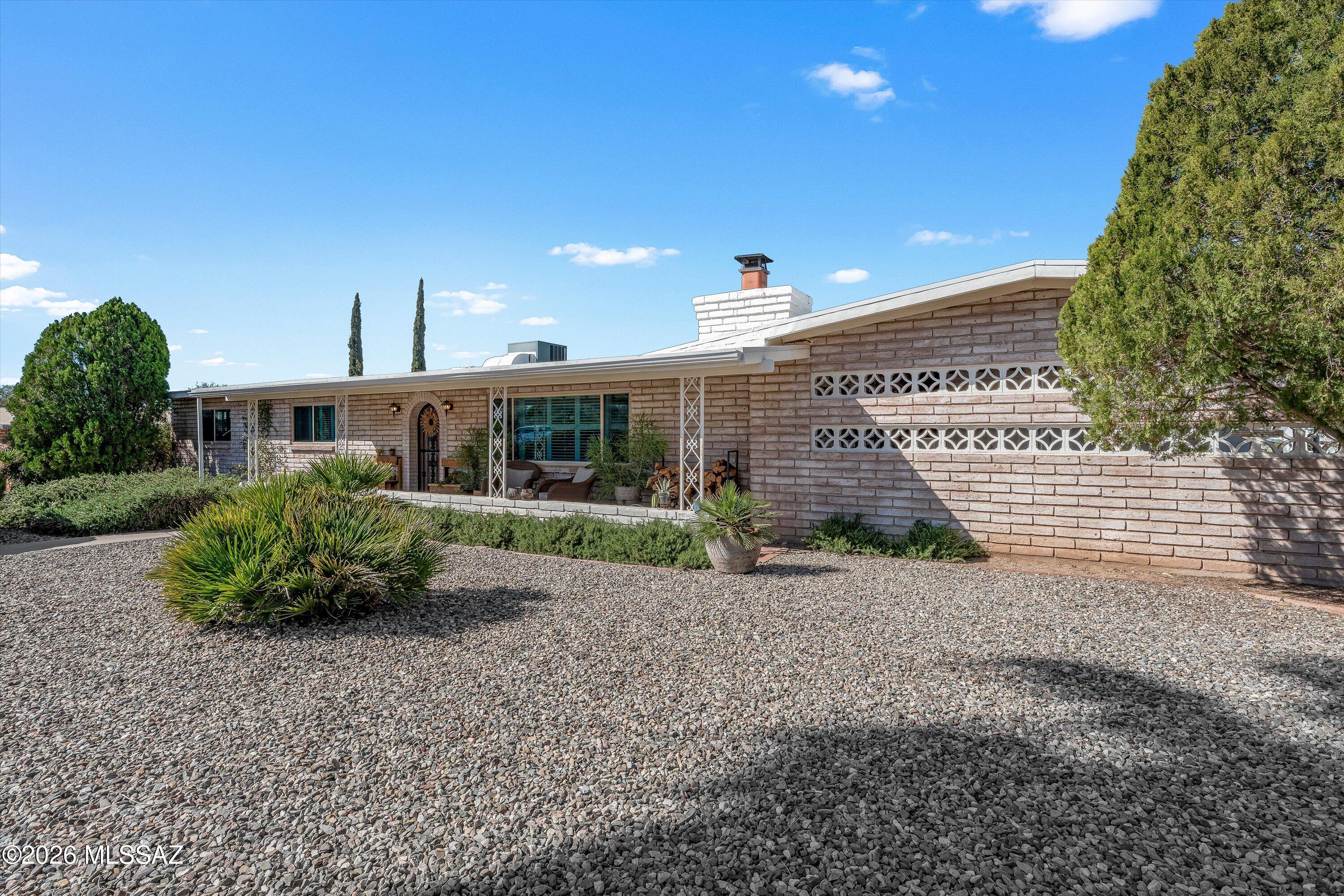 A Midcentury Charmer, in one of the most quietly convenient and sought-after areas of town! This home has been tastefully brought up to contemporary standards, while still keeping its historic charm. Set on .82 acres with no HOA, this 3 bedroom, 2 bath home features gorgeous concrete floors, wood-burning fireplace, kitchen with gas, and deep front and back porches, perfect for your morning coffee or evening beverages. Seller has upgraded with energy efficiency in mind- new windows, upgraded electrical panel, added solar, redone the roof, blown in new attic insulation, and reworked the landscaping. Seller has added two beautiful steel ramadas in the backyard, painted, rehabbed the fireplace and more. It's hard to find a home so cozily updated- all within 2 minutes of great shopping + dining