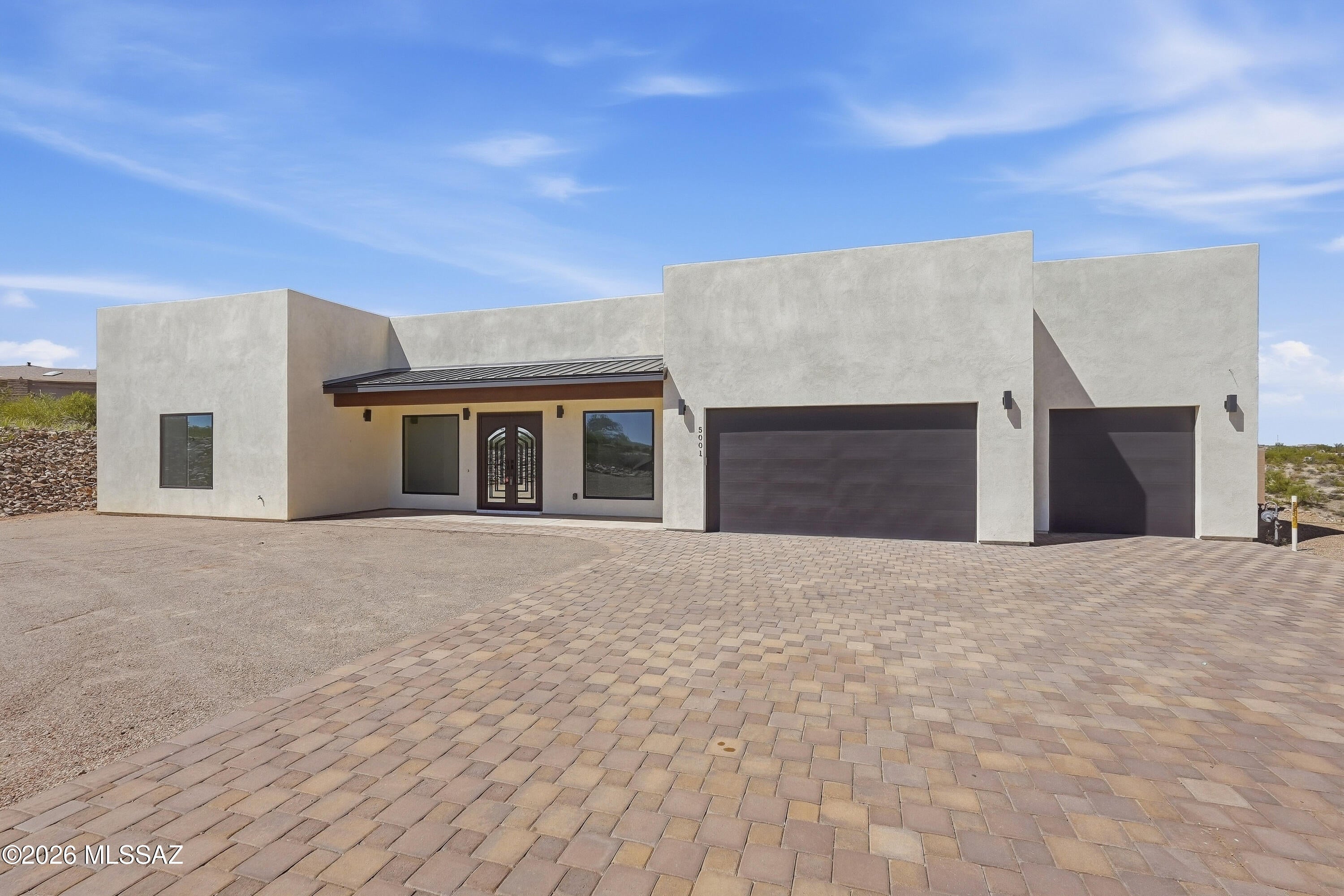 Discover unparalleled desert luxury in this 2023 modern masterpiece set on 1.18 acres in prestigious Gracious Estates. Sophisticated design meets serene living with soaring ceilings, a grand great room anchored by a gas fireplace, and a chef's kitchen boasting a prep sink, walk-in pantry, and statement island crafted for lavish entertaining. Dual spa-style primary suites offer a indulgent soaking tub and sleek walk-in showers. Outdoors, savor panoramic mountain, sunrise, and sunset views from the covered patio.  With refined finishes, a 3-car garage, and breathtaking natural surroundings, this residence delivers elevated living at its finest.