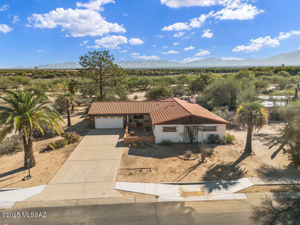 Spacious 2,805 sq. ft. home on a rare .82-acre lot in a 55+ community with Green Valley Recreation access. This property offers wide streets, no rear neighbors, and peaceful pecan orchard views with a peek-a-boo mountain backdrop--providing a level of space and privacy that's uncommon in the area. Inside, you'll find a flexible floor plan featuring a charming beehive fireplace in the main living area and a spacious Arizona room with a wood-burning fireplace, framed by Andersen Renewal sliders that bring in abundant natural light. Did I mention re-roof was just in 2018!!! The home includes guest quarters with two private entrances, a generous bonus room off the kitchen ideal for hobbies or a home office, and multiple living spaces that allow room to spread out and comfortably accommodate everyday living, entertaining, or multi-generational needs with ease. Residents enjoy access to Green Valley Recreation's pools, fitness centers, clubs, and activities, along with nearby Desert Meadows Park featuring scenic walking paths and desert gardens. Experience comfort, community, and classic Arizona living with space to make it your own.