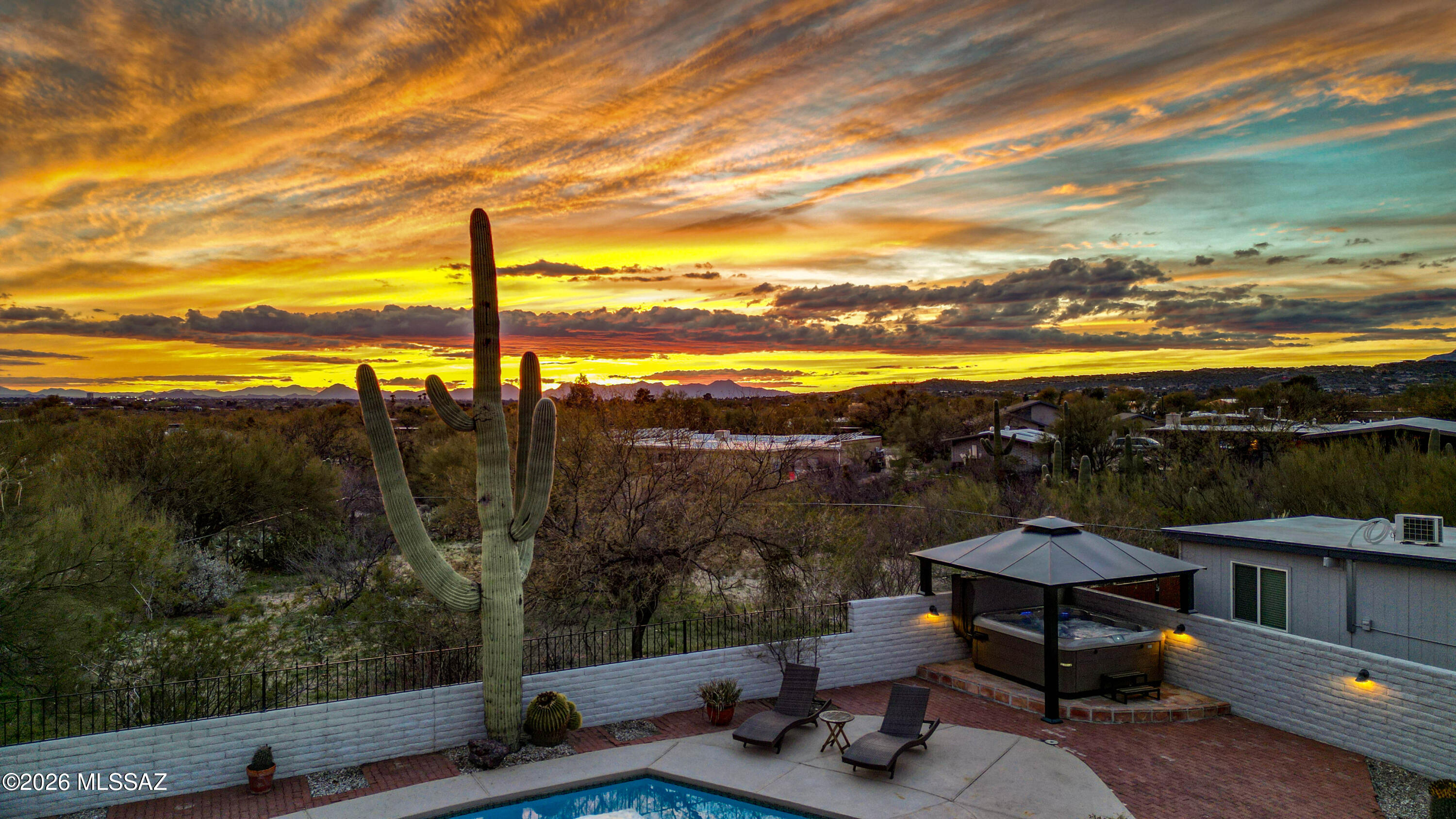Fully furnished and turnkey - perfect as a primary residence, winter retreat or an Airbnb investment. This move-in ready 4 bedroom/2 bathroom masonry home is sited on a .83 acre lot located in the desirable neighborhood of Rinconada Hills. Nestled within one of Arizona's most breathtaking desert landscapes, this single story home is infused with natural light & nature's beauty while offering many of today's modern conveniences. The open floor plan concept is perfect for today's active lifestyle and features a spacious living and dining area with durable concrete flooring throughout, wood burning fireplace and access to the covered patio. The kitchen features gorgeous quartz countertops, stainless steel appliances, coffee bar, wine refrigerator and plenty of cabinets & counter space.  Retreat to the relaxing primary suite with en-suite which has a large walk-in shower & spacious closet.  Both secondary bedrooms have queen beds. The detached Bunk House offers numerous options: office/art studio/exercise room, and has two twin over full bunk beds as well as two futon sleepers, couch, chairs, dining set and an HVAC mini-split. Enjoy year round entertaining and outdoor dining on the private covered patio with a large heated pool, spa, built-in BBQ grill and multiple outdoor seating areas which allow you to immerse yourself in the beauty of the Sonoran Desert and its lush vegetation, cacti and natural wildlife.  Close to Mt. Lemmon for bike enthusiasts, Sabino Canyon Recreational Center for runners & hikers, Bear Canyon Trailhead, and both Agua Caliente & McDonald Parks.  Resort style living at its best where everyday feels like a vacation!