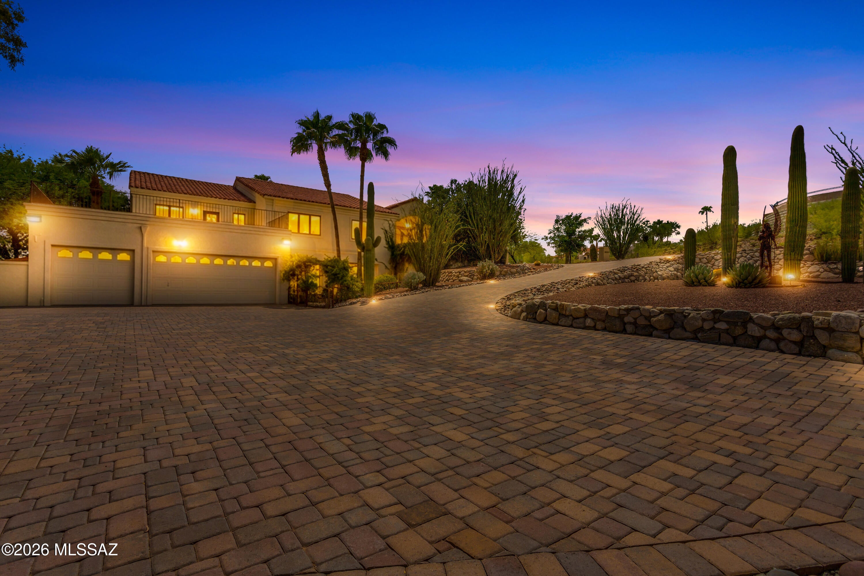 Nestled in the prestigious Canyon Ranch Hills, sitting on over an acre is an immaculate Tuscan Estate. This 6,300sqft home has breath taking views of the Catalina and Rincon mountain ranges as well as city lights. Pulling into the expansive brick paver driveway, you'll immediately notice Ariel Guardian Of The Desert prominently displayed in the zeroscaped front yard. The life sized winged metal sculpture sits upon its pedestal with a semi circle back drop of massive saguaro cacti. As one traverses the sloped brick paver driveway, her ethereal figure disappears and reappears dependent on ones position. Commissioned by the owners, Internationally acclaimed local artist John Benedict created this beautiful one of a kind statue. Illuminated by a Magnetic Power Pack Portfolio lighting system Ariel stands out day and night. The Lighting System runs through the pavers and illuminates the zeroscaped yard as well. 
 Vehicles are sheltered in an extra deep three car garage. The front yard also boasts a custom Tuscan garden, as well as several unique gates, and a wrought iron door custom made by Painted Gecko Iron works. Stepping into the foyer, your greeted with vaulted ceilings, wood framed Pella Windows, and porcelain tile with Italian Medallions. Looking around the expansive top level you'll notice a thoughtfully laid out floor plan. To the right is the spacious master bedroom with a walk-in closet featuring a fireproof custom safe. To the left of the walk-in closet is the Tub/Bidet room with a spa soaker tub. On your right is the shower room, with another toilet and full vanity. Stepping out you'll notice the dining area and its Swarovski French Empire Crystal Chandelier with 3,378 crystals. Step into the custom wood cabinet kitchen with granite counter tops, gas cooktop, and stainless steel appliances. Don't miss the dumbwaiter, it makes bringing up groceries from the lower level effortless. There's an additional three nicely sized bedrooms, two of which have walk-in closets, and the third guest bedroom doubles as an office with a custom Murphy bed. Supporting those rooms are two full hall baths. You'll also find a recently remodeled laundry room with granite counter tops, custom cabinets, and a brand new all in one Samsung washer/dryer that was completed in June of 2026. The Living room has a cozy fireplace, hardwood floors, bar top seating, and a breakfast area with city views. Heading down the well lit stairs to the lower level you'll be amazed by the stone fire place, a custom wet bar that has quartz counter tops, a wine fridge, ice maker, soda dispenser, dishwasher, and stainless steel sink. On the lower level you'll also find an 1800 bottle, custom made, Temp/humidity controlled wine cellar. There is a gym with cork board flooring and a media room with 7.1 surround sound and a 90'' screen. There is a fourth bathroom with a copper sink, butlers pantry with granite counter tops, and an extra fridge. Next, step into the breathtaking library that has 500sqft of custom solid oak floor to ceiling shelving on three walls, with plenty of room to sit and read while looking out the window at the mountain views. Heading outside to the east portion of this immaculately maintained yard features an above ground hot tub with waterfall, a 30,000 gallon pool with auto cover, and the smaller Koi pond. Massive queen palms, and mature trees dot the landscape. Along the east elevation there's a turtle pond, dog run, vegetable garden, and a 160sqft work-shop. Headed back to the west end you'll pass by the multi-tiered fountain nestled in the stunning rose garden. Step up and to the left and you'll see the Japanese Garden with the granite lanterns and the 15,000 gallon Koi pond. Home to over 40 Koi fish of varying sizes, it features a lazy stream that runs down and gives a peaceful atmosphere. Turning back towards the home you'll notice the mix of mature citrus trees, the AZ Luxury Lawn, gazebo, and the fully equipped outdoor kitchen. This kitchen has it all; stainless steel appliances, Lazyman grill with two side burners, overhead exhaust vent, dishwasher, and granite counter tops. Attached is a recently built bathroom completed in winter of 2025 and a pond storage room with refrigerator. There's also a fire pit with plenty of available seating. Step up to the back porch that features sweeping mountain and city views as well as three Suncontrol Shades with power controller.

 The Catalina mountain views from the front balcony, to the city views off the back porch you truly see all of Tucson. It includes whole home filtration, a new ac unit, and massive amounts of storage. This home truly has it all. Don't miss out on your opportunity to own this one of a kind, diamond in the desert!