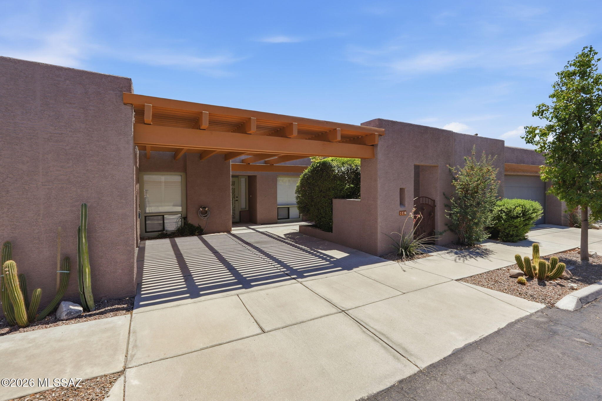 Great central Tucson location with easy access to The Loop! This charming townhome offers comfortable, low-maintenance living with plenty of recent updates, including a new roof (2026), fresh interior and exterior paint, updated fixtures, new refrigerator, and a beautifully remodeled primary bath with custom tub/shower surround.  The spacious living room features vaulted ceilings, a fireplace, stained concrete floors, plantation shutters, and French doors opening to the private patio. The kitchen offers a breakfast nook and pantry, with flexible space for additional dining. The primary suite includes a walk-in closet, dual vanities, extra linen storage, and a slider to the backyard. A north-facing guest bedroom, laundry closet with newer washer and dryer, and additional storage off (more) the courtyard/carport add everyday convenience. Outside, enjoy a private patio with fireplace, banco seating, and a mature tree. Backing to a common area for added privacy, this inviting home is tucked into a charming boutique community while keeping you close to everything Tucson has to offer.