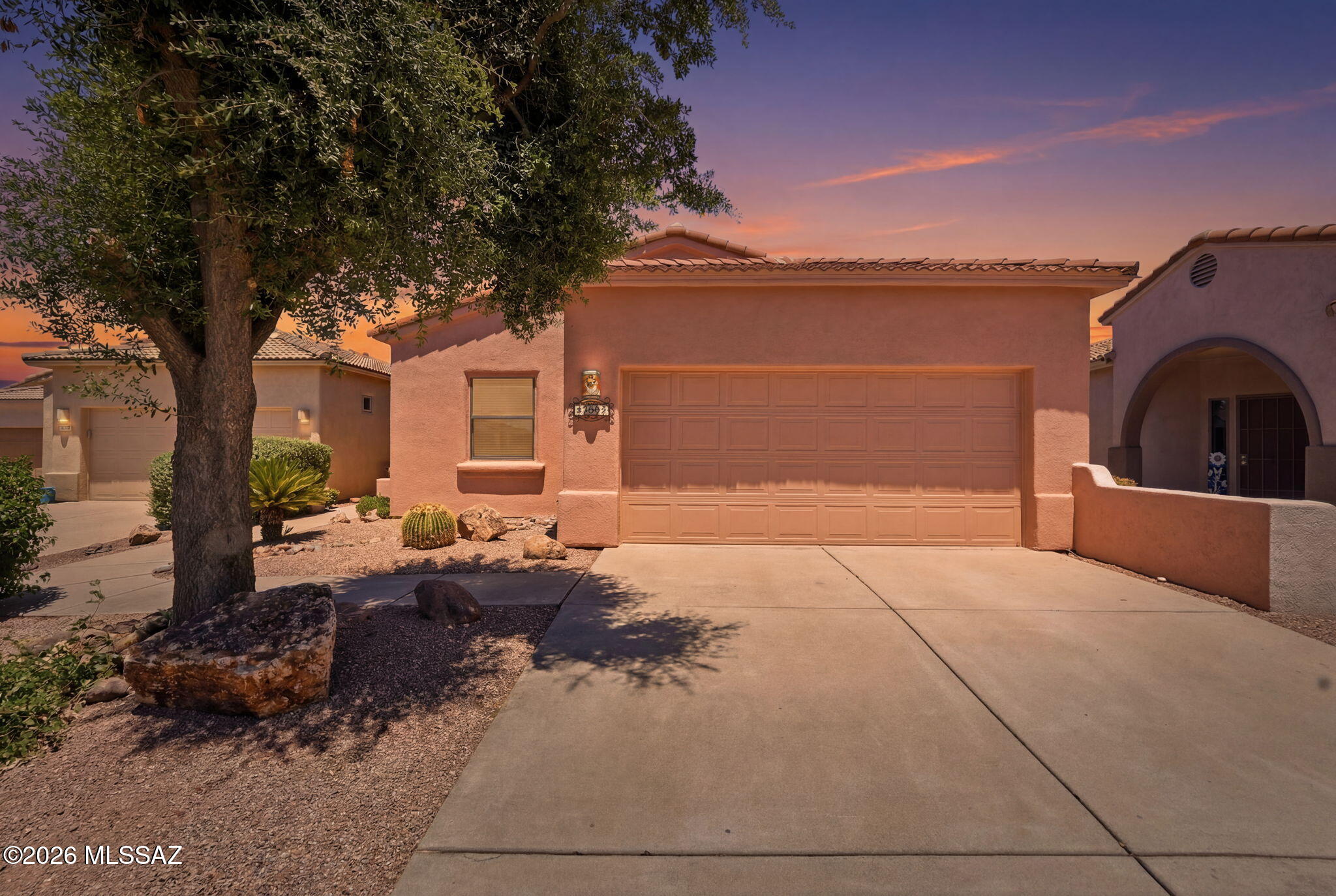 This turn-key home in the Presidio at Santa Rita Springs has been freshly painted both inside and out, offering a move-in-ready opportunity in one of the area's most desirable neighborhoods. Built by Monterey Homes, this well-crafted residence features a spacious two-car garage and a thoughtfully designed split-bedroom floor plan that provides both comfort and privacy. Attractive curb appeal welcomes you home with a private sidewalk leading to the front entrance, a cozy seating area, and an impressive designer security door that allows refreshing breezes to flow through while keeping unwanted critters outside. Step inside and immediately appreciate the abundance of natural light and the multiple sight lines that create an open and inviting atmosphere throughout the home. The spacious great room provides the perfect setting for your living room furnishings and offers plenty of room to relax, entertain guests, or enjoy a quiet evening at home. The kitchen is truly stunning, showcasing elegant, staggered wood cabinetry, gorgeous granite countertops, ample workspace, and timeless finishes that are sure to impress. Just off the kitchen, the breakfast nook is surrounded by windows, creating a bright and cheerful space to enjoy your morning coffee while catching up on the latest news or planning your day. The primary suite is a peaceful retreat featuring luxury vinyl plank flooring and a ceiling fan that helps maintain year-round comfort. The spa-inspired en-suite bathroom boasts vessel bowl sinks set atop quartz countertops, designer mirrors, upgraded lighting fixtures, and a beautifully appointed walk-in shower with tasteful tile surrounds and easy accessibility. The guest bedroom is conveniently located next to a comfortable guest bath and offers exceptional flexibility, making it ideal as a bedroom, home office, hobby room, or a combination of all three. Friends and family visiting from out of town will feel right at home. Outdoor living is equally enjoyable with a covered patio, an attractive stone patio, and a stone walkway that enhance the backyard's appeal. There is plenty of room for outdoor furnishings, allowing you to relax, entertain, and take in the beautiful views of the Santa Rita Mountains. Combining quality construction, thoughtful upgrades, and an excellent location, this home also includes membership to Green Valley Recreation, giving you access to the many recreational, social, and fitness amenities that make Green Valley such a wonderful place to call home.