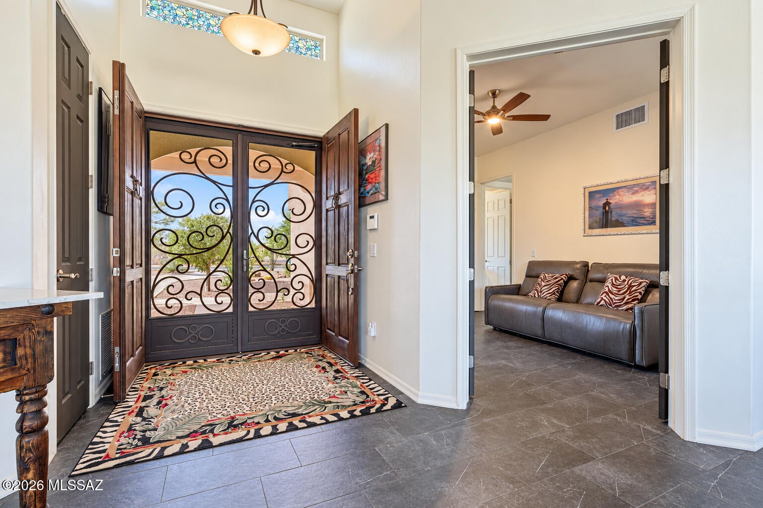 Among the best wildlife and sunset views in Vail's Coyote Creek, in the Rincon Valley Foothills east of Tucson. Move-in ready 2016 Sombra Homes custom, single level with no stairs inside. 3 bedrooms plus a den for office or guests, 3 full baths, 2,700 sf. Panoramic Rincon Mountain views through walls of glass in an open great room, Santa Fe style throughout. Granite island kitchen with gas cooktop. Spa-style primary with dual vanities and soaking tub. Porcelain tile, zero carpet. Hand-forged iron entry and back doors. Pella Low-E windows and Rhino Shield 20-year paint. Transferable roof, HVAC and appliance warranties plus ADT. Oversized 3-car garage. Minutes from Saguaro National Park.