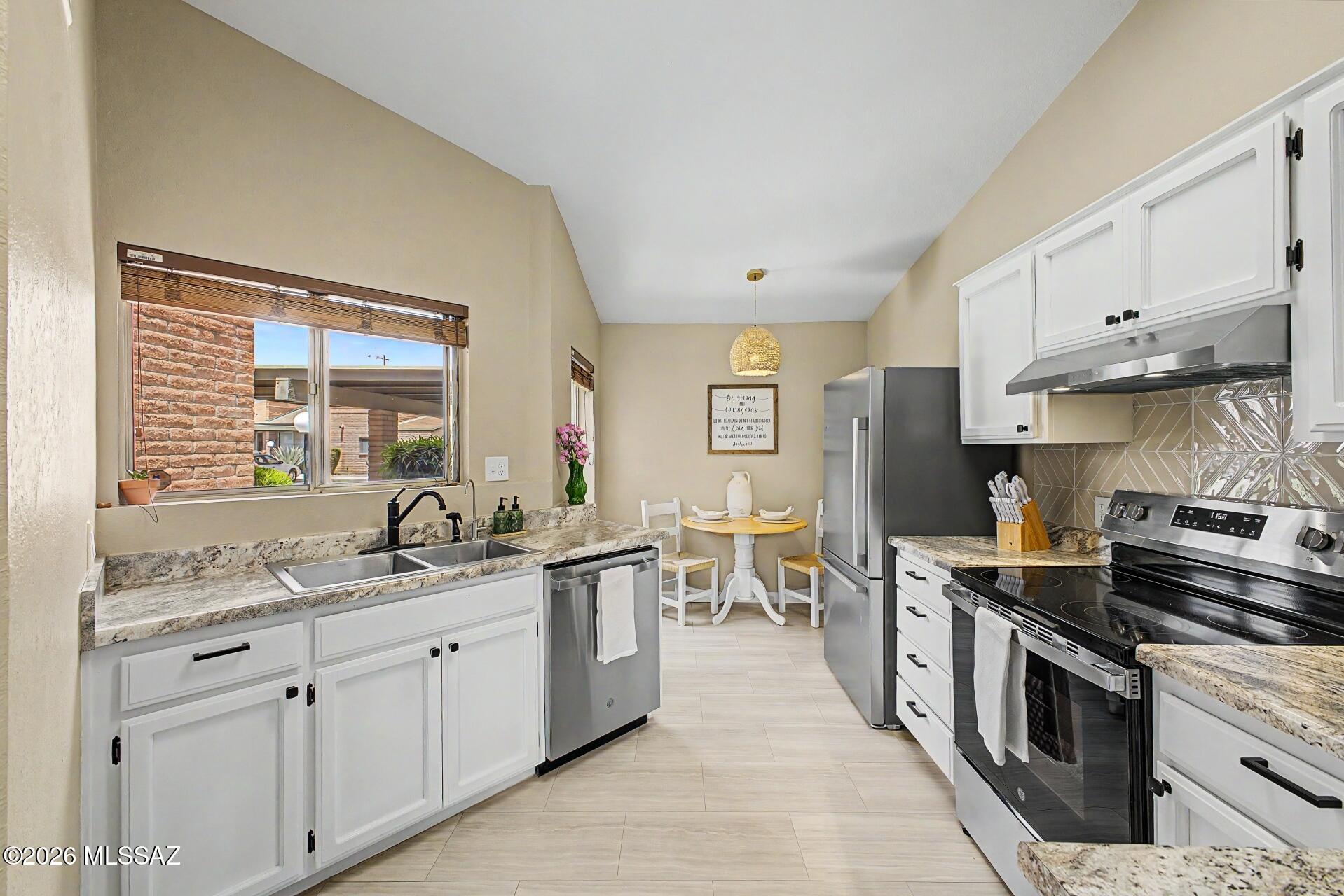 Tucson living at its best. This 2-bedroom, 2-bathroom classic Tucson brick townhome offers  comfortable, light-filled living in the heart of central Tucson. Easy living is the theme and the updates support that. Newer roof & HVAC, new electrical panel, fresh interior paint, new light fixtures, and updated door hardware throughout. Inside you will find fresh LVP flooring, a fully remodeled kitchen with stainless appliances, a skylight that fills the living room with natural light. The wood-burning fireplace with beautifully finished surround is a stunning focal point. The primary bathroom has been thoughtfully updated. All appliances convey including washer and dryer. The HOA covers water, sewer, trash, front yard maintenance and a beautifully maintained clubhouse, sparkling pool and spa. Step outside to your private covered patio, perfect for Tucson mornings year round. The community amenities are the cherry on top and make this home feel like resort living. Truly turnkey living. Conveniently located near U of A, TMC, shopping, dining, and major corridors, everything you need is within 10 minutes. Easy connectivity to The Loop, Tucson's renowned 131-mile path perfect for cycling, walking, and outdoor living. This is Tucson living at its best.