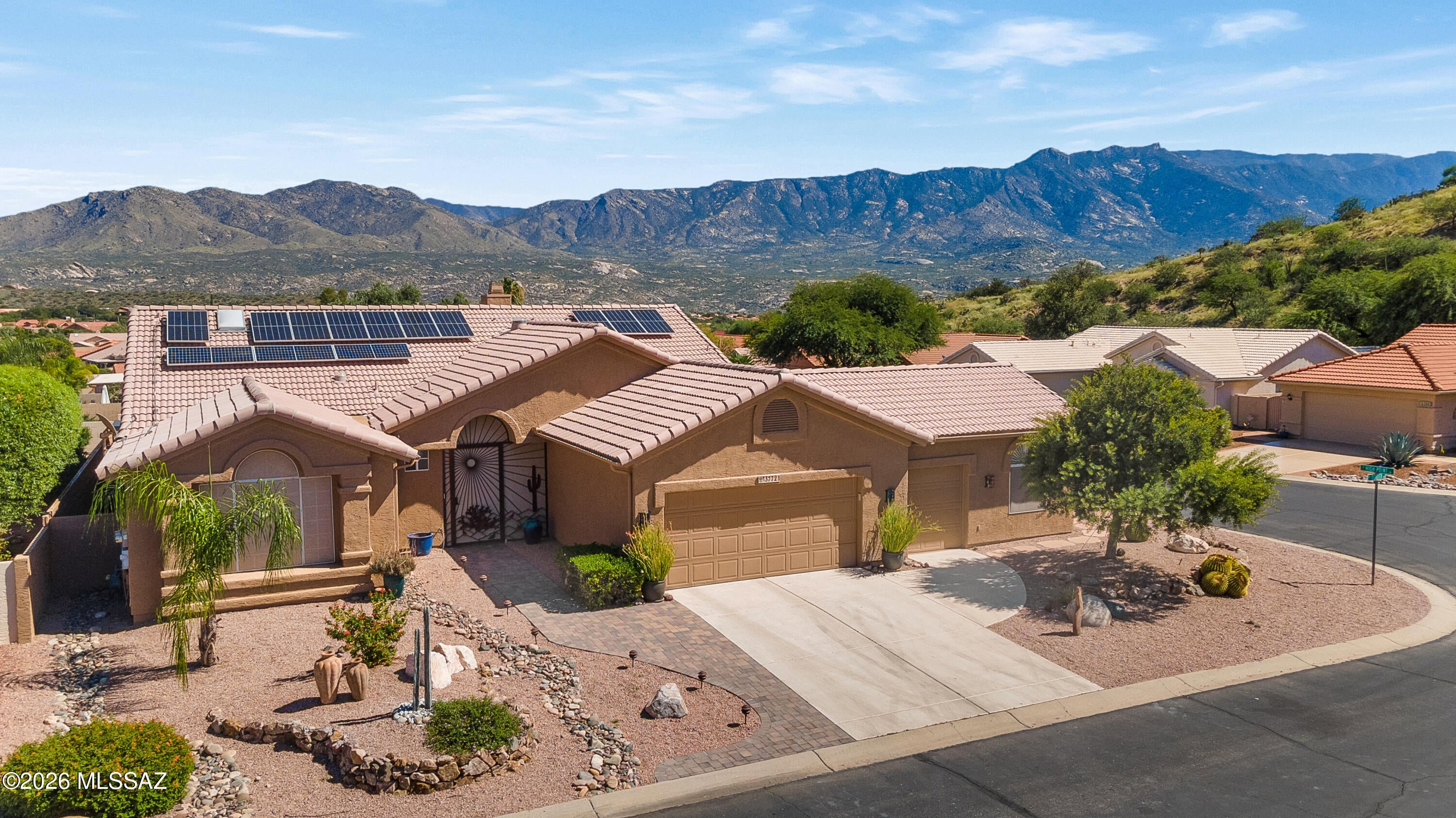 Stunning Mountain Views, Resort-Style Living & Room to Pursue Your Passions! Discover this beautifully customized 2,689 sqft 3BR/2BA retreat featuring saltwater pool and spa, detached STUDIO, owned solar + expanded 2.5-car garage w/golf cart space. Private corner lot offers spectacular Catalina Mt views, expansive paver patios & three pergola-shaded outdoor living areas + pet safe AZ Room. Thoughtful modifications enhance the home's comfort & flow. Central 2-sided fireplace connects distinct living spaces while the expanded kitchen and adjoining dining area invite effortless entertaining. The light-filled kitchen w/vaulted ceilings, striking granite tops, slate appliances w/gas cooktop, handblown pendants & peninsula seating, with dramatic arched picture window framing pool & mt views. Create, work, exercise or unwind in the private Studio, with French doors opening to a shaded patio overlooking the pool and mountains. Beautifully remodeled primary bath features an extended dual-sink quartz vanity with central storage tower and a spa-like walk-in shower with marble-look tile, river-rock flooring, built-in bench and textured glass partition. Separate private guest wing with full bath add versatility for guest stays or owner use as den.

Resort-style outdoor living includes three shaded pergolas, expansive paver patios, a PebbleTec saltwater pool and separate spa, both solar and gas heated.

Energy-conscious upgrades include new windows and an owned 28-panel solar system installed in 2020 with remainng warranty. Most roof underlayment has been replaced with warranty coverage, and HVAC systems have been regularly maintained.

Experience the views, embrace the lifestyle and discover the possibilities--schedule your private tour today!
