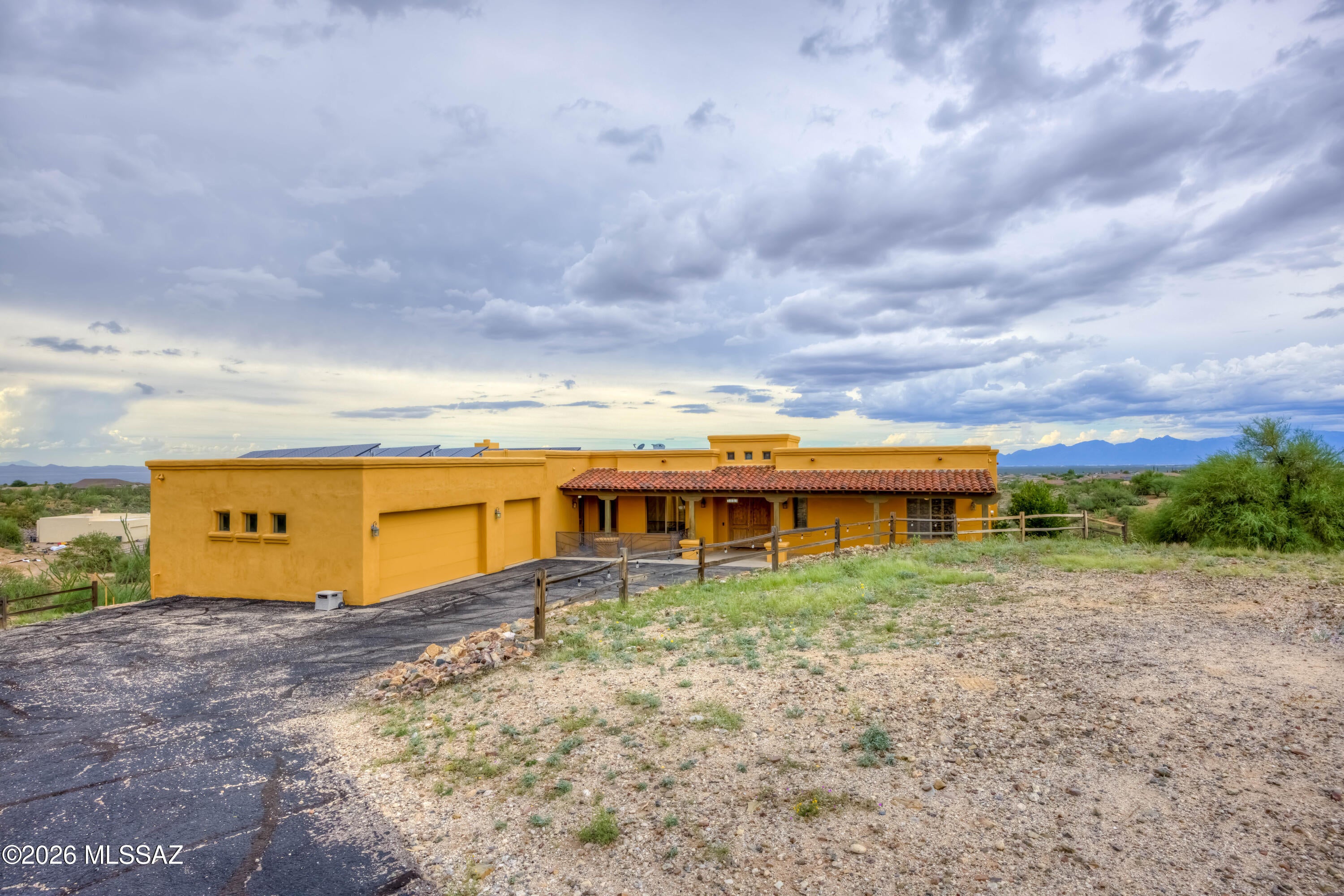 Situated on an elevated 1.15 acre lot, this exceptional 3,256 sqft. home offers panoramic views, incredible privacy, and an outdoor setting that feels like your own private retreat. With 3 bedrooms, 3 full bathrooms, a den, 3 car extended length garage, RV space, and no HOA, this property offers both space and flexibility. Enter through the double doors into an inviting foyer featuring beautifully detailed custom tile work that creates an impressive first impression. Just off the foyer is a versatile den/bonus room, perfect for a home office, library, or additional living space. The spacious kitchen is designed for both everyday living and entertaining, with an abundance of cabinetry and counter space, a huge pantry, dining nook, breakfast bar, prep sink conveniently positioned near the dining area for easy cleanup and loading of the dishwasher, two brand-new dishwashers, double ovens, a large island with cooktop, and a built-in desk. The adjacent living room features a charming kiva fireplace, extensive built ins, and a generous entertainment area large enough to accommodate a substantial TV.

The generously sized laundry room provides plenty of storage with extensive cabinetry and counters, plus an additional refrigerator.

The private primary suite is a peaceful retreat with direct access to a secluded courtyard designed specifically for dogs, complete with turf and a covered enclosure for added protection. The luxurious primary bathroom features a large soaking tub, separate vanities, built in vanity area, abundant cabinetry and drawers, and a large step in shower. The oversized primary closet provides exceptional storage.

The additional two bedrooms are generously sized and share two full bathrooms, providing plenty of space for family and guests.

Step outside and discover an incredible backyard oasis surrounded by spectacular views in every direction. Enjoy the Arizona outdoors from the screened in patio or relax poolside with the sparkling pool, spa, and charming cabana. The pool features adorable dolphin fountains that add a fun and distinctive touch to the outdoor space. The expansive lot provides plenty of room for RV parking and outdoor enjoyment while maintaining an exceptional sense of privacy.

With panoramic hilltop views, 1.15 acres, a resort style backyard, spacious living areas, an extended 3 car garage, RV space, and no HOA, this property offers a rare combination of privacy, functionality, and Arizona outdoor living. PLUS OWNED SOLAR! Homes like this are hard to come by, and won't last long!!