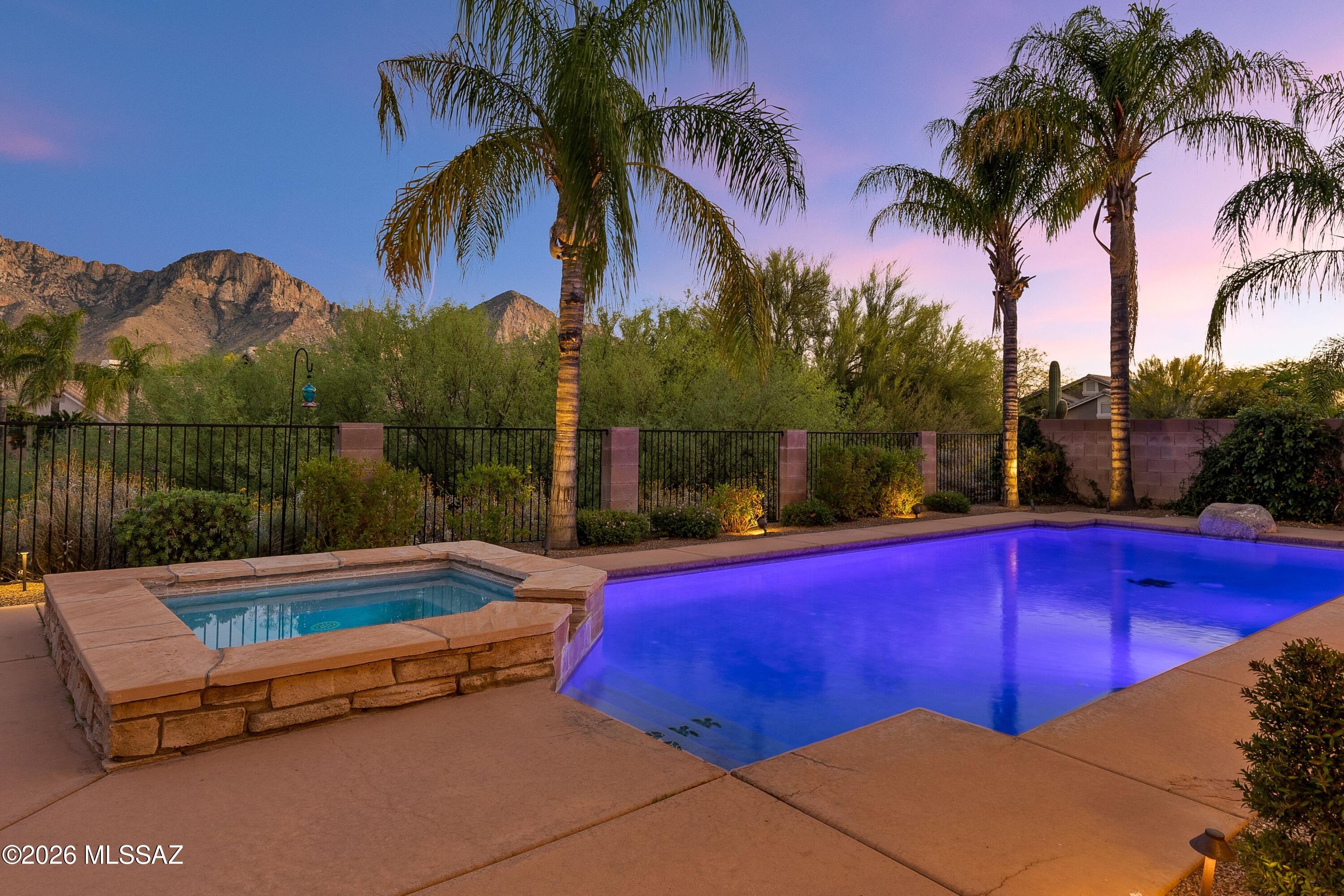 Dramatic views of Pusch Ridge and the Catalina Mountain range await at 1550 E Ganymede Drive. Situated on an elevated SE facing lot in the convenient neighborhood of Catalina Shadows, this property has it all: ample space, outdoor living & gorgeous desert scenery. Iconically Southwest, the Santa Fe style architecture nods to the setting. Inside, a spacious layout with 3,103 sq ft includes 5 bedrooms (main level primary), 2 ½ bathrooms with dual living spaces - you will find fresh paint throughout. High ceilings & large windows create a sense of openness. Fully renovated, the chef's kitchen is the heart of the home. Outfitted with floor to ceiling custom cabinetry, stainless appliances-including a BlueStar range, and a generous island finished with satin granite counters and wainscoting. Recently enhanced with a new picture window, the breakfast nook provides a perfect visual path to the beaty outside. The downstairs primary bathroom has been refreshed with new tile, painted cabinetry, lighting and accessories.

Leading to the second level, oak hardwood flooring has been added to the staircase and landing. The guest bath has been fully remodeled with new flooring, cabinetry and countertops. One of the four guest rooms is oversized, which could be generous bedroom, playroom, media room or other use.

Outdoors, a resort-style environment is showcased, all with unobstructed views of the mountains. Alongside the large beautifully designed linear pool and raised spa there is a gas firepit and built in grill. Ample space under the covered patio allows for multiple seating areas, perfect for gatherings or spreading out.

Within a 3-mile radius, there are abundant amenities that make this location extremely convenient, including; Oro Valley Marketplace, Catalina State Park, Oro Valley Hospital, shopping plazas with grocery services, dining, Home Depot, Target, gym facilities and more. Access to multi-use paved trail systems for cycling or running are immediately accessible, while world class mountain biking trails are also close by. The Oro Valley Farmer's market can be easily reached by bike or a short drive.