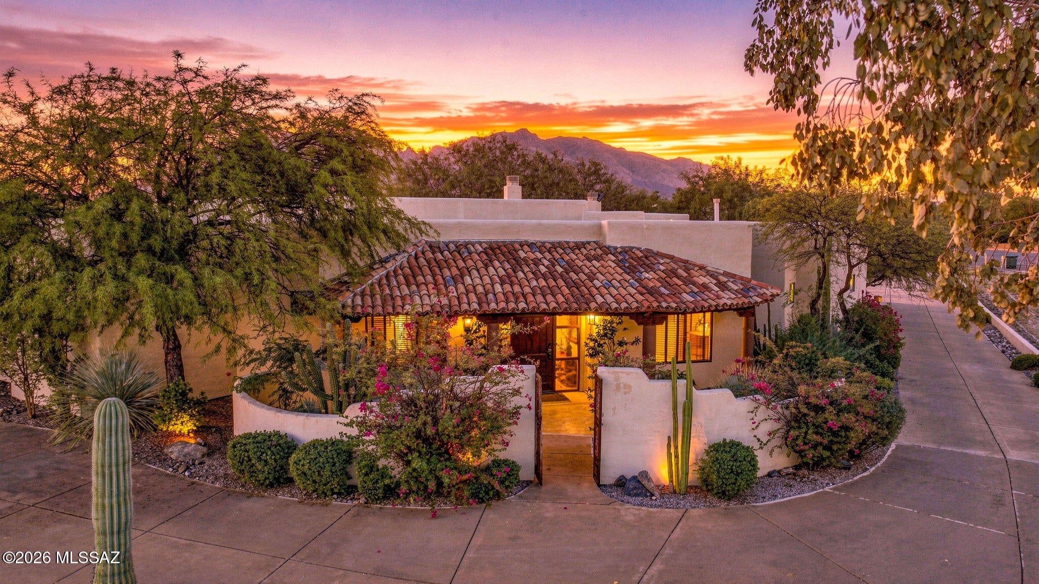 Tucked away on a private drive amidst a canopy of mature trees and lush desert landscaping, this exceptional Casas Adobes residence offers a rare sense of privacy and tranquility while remaining moments from Tucson's finest dining, shopping, and everyday conveniences (La Encantada, Whole Foods, Oracle and Ina Shopping)! Thoughtfully designed and meticulously maintained, this is a home where pride of ownership is evident at every turn!
From the moment you arrive, the home creates an immediate sense of arrival. Mature landscaping, inviting architecture, and a peaceful setting give way to interiors filled with soaring ceilings, generous proportions, and remarkable sightlines that draw your eye through the home and into the backyard beyond! Every space feels open, connected, and filled with natural light! Designed around a highly desirable split-bedroom floor plan, the layout offers exceptional flexibility for both everyday living and hosting guests. The expansive primary suite is a true retreat, while secondary bedrooms enjoy privacy of their own. Rich finishes, custom details, abundant storage, and oversized living spaces create a home that is as functional as it is beautiful!
At the heart of the residence, the chef's kitchen flows effortlessly into the great room and outdoor living spaces, making entertaining feel effortless. Large windows frame the surrounding landscape, creating a constant connection to the lush gardens and peaceful outdoor setting!
Step outside and discover your own private resort. The backyard has been lovingly cultivated into a secluded sanctuary, where mature trees, vibrant landscaping, and carefully designed outdoor spaces create an atmosphere rarely found in the desert Southwest. Lounge beside the sparkling pool, relax in the spa, enjoy evenings beneath the covered patio, or simply take in the sounds of birds and rustling trees. Every inch of the property has been thoughtfully cared for and designed to be enjoyed year-round!
Beyond its beauty, this home offers the confidence that comes with exceptional stewardship. Every system, finish, and landscape element reflects years of attentive maintenance and thoughtful ownership, providing a level of quality that discerning buyers immediately recognize!
Located in one of Tucson's most established and sought-after neighborhoods, this home combines timeless architecture, remarkable privacy, mature landscaping, and an effortless indoor-outdoor lifestyle into a rare offering. For the buyer seeking refined desert living without compromise, this is a residence that simply feels like home!