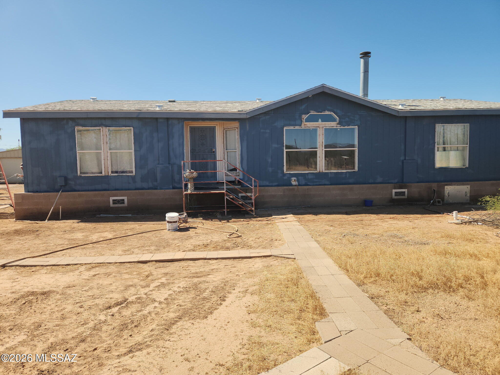 New on the market for the first time in over 20 years! This 1456 square ft 2003 manufactured home sits on 4 fully fenced acres with gated entry and two access points for convenience. A standout feature is the large workshop, complete with a wood-burning stove and swamp cooler, perfect for woodworking, welding, mechanical projects, or any hobbyist's needs. Inside, the home showcases a open functional kitchen with abundant storage. Take in breathtaking sunsets and endless star-filled skies from your own rural retreat. FHA, VA, Conventional, or cash. Tour this home today and make an offer on your forever retreat!