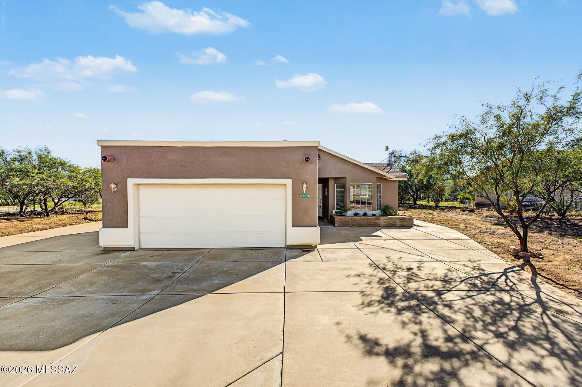 This spacious 3-bedroom, 2-bathroom home sits on an expansive parcel of over half an acre, offering both privacy and room to breathe. Well-maintained throughout, the interior features durable, easy-to-clean tile flooring across all main living areas. At the heart of the layout is a bright great room that seamlessly opens to the kitchen, creating an inviting space for everyday living and entertaining. A desirable split floor plan places the primary suite on the west side for optimal personal space away from the secondary bedrooms. Outside, you will find a covered patio perfect for taking in the stunning surrounding views, along with a functional two-car garage for parking and extra storage.
