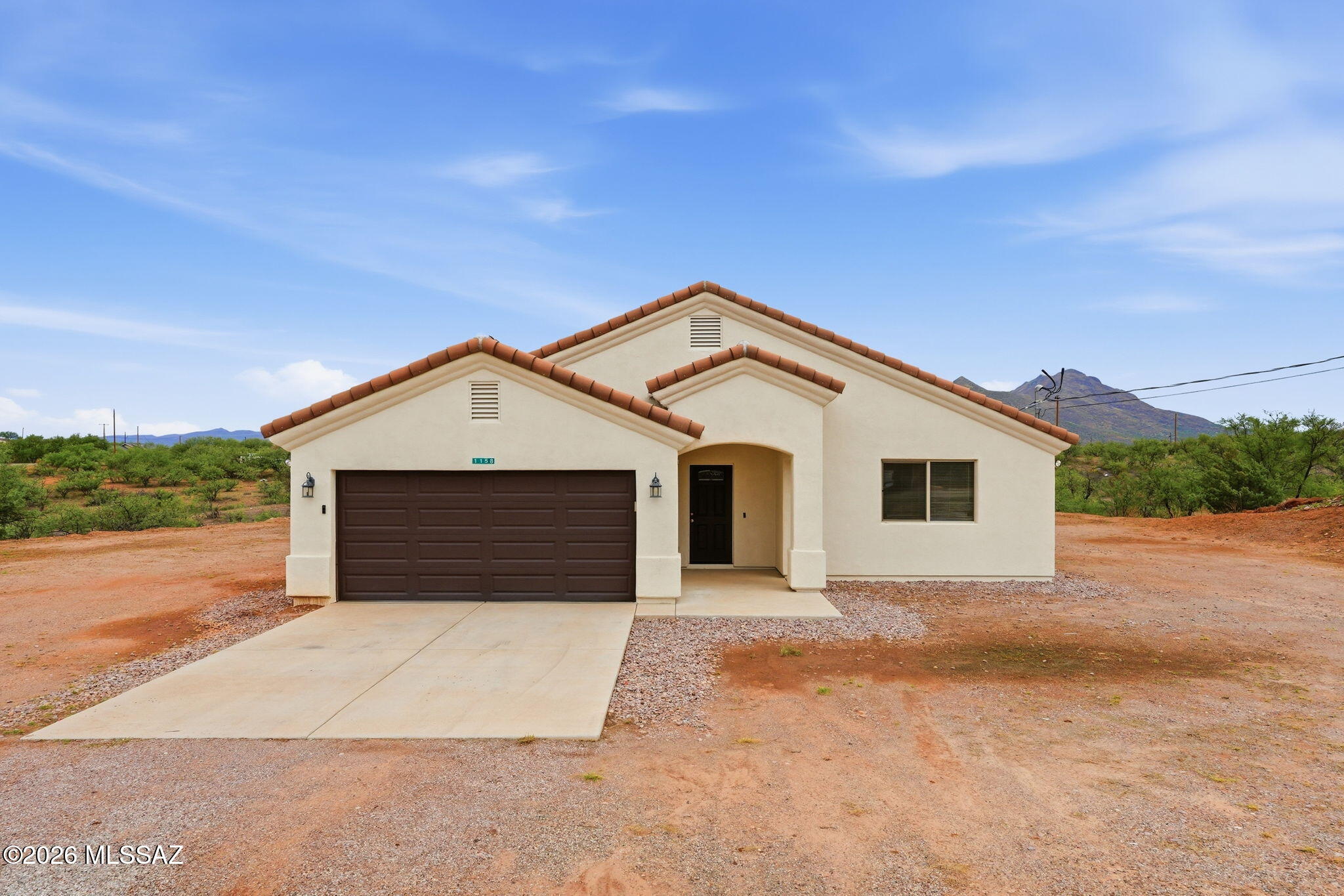 Welcome to 1158 Escorpion Ct, where modern comfort meets the peaceful beauty of Rio Rico. Built in 2021, this well-maintained 3-bedroom, 2-bath home offers 1,589 square feet of thoughtfully designed living space on an expansive 0.77-acre lot with breathtaking mountain views.

Step inside to discover an open, inviting layout highlighted by vaulted ceilings, ceramic tile flooring throughout, and stylish granite countertops. The kitchen offers privacy from the main living area while remaining conveniently connected to the dining space, making it ideal for both everyday living and entertaining. The spacious primary suite and dining area frame picturesque mountain vistas, creating a relaxing backdrop to your daily routine.

Outside, the oversized lot provides abundant usable space for outdo living, gardening, or future possibilities. A covered patio, two-car garage, and contemporary finishes complete this move-in-ready home. Enjoy the tranquility of Rio Rico while still being conveniently located near local amenities, schools, and I-19 for an easy commute.

Don't miss this opportunity to own a newer home with stunning views, modern finishes, and room to grow.