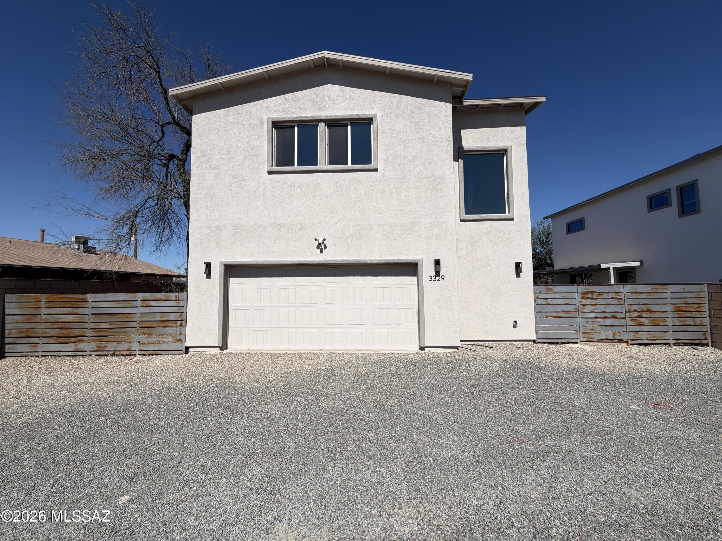 Modern, private, gated 4BR/3.5BA contemporary home featuring high ceilings, mountain views, and wood-plank tile throughout. The open kitchen boasts quartz counters, black stainless appliances, and a large island. Upstairs includes four spacious bedrooms with walk-in closets, two ensuite baths, a laundry room, and a covered deck with panoramic Catalina and Rincon views. Conveniently located near the UofA and downtown.