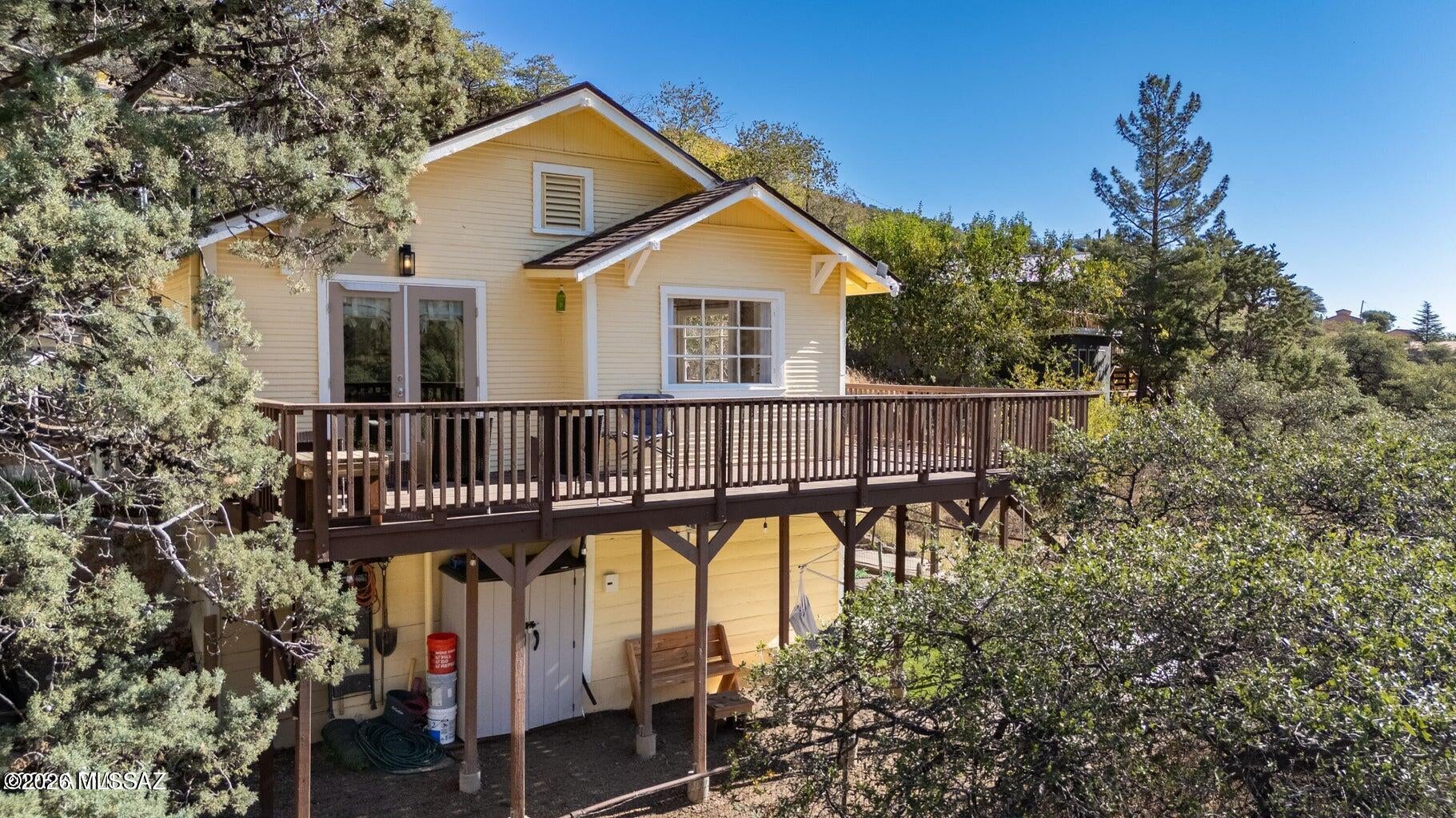 Newly Renovated with Outstanding Revenue Potential! TWO PARKING SPOTS, one with an EV charging station! This beautiful 1930 bungalow in historic Old Bisbee offers beautiful views and flexible living options. Fully renovated in 2024 with a new roof, updated systems, a kitchen with granite countertops, and energy-efficient mini-splits, it's ready for a full-time home, vacation getaway, or income-producing investment. The main level has 2 beds, 1 bath, a full kitchen, and living room. Also added in 2024, the private lower-level studio has a kitchenette and 3/4 bath, ideal for guests, extended family, or rental income. Both levels are currently used as Airbnbs. Relax on the wrap-around deck and enjoy nearby arts, restaurants, shops, parks, hiking trails, and Bisbee's cooler mountain climate. Furniture available on a separate bill of sale at closing.