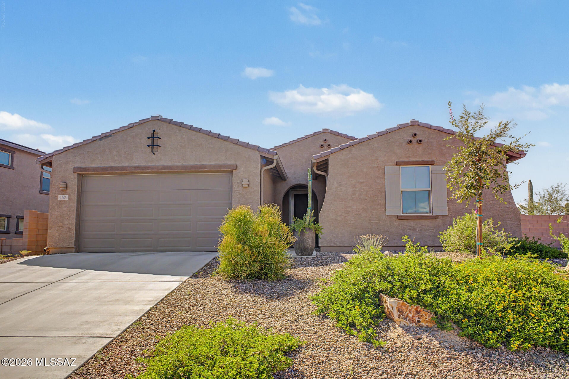 Beautifully upgraded single story home on a corner lot in gated Oro Valley built in 2022. Welcome to this stunning 2,343 sq ft home with 3 bedrooms, 2.5 baths and spacious 3-car tandem garage. The great room concept creates an inviting flow between the living and dining areas with a generous island, quartz countertops, light-colored cabinetry, designer lighting, large walk-in pantry and ceramic tile throughout. The kitchen is equipped with KitchenAid appliances including a gas cooktop and refrigerator. The primary suite features an impressive oversized walk-in shower and dual vanities. The private backyard is beautifully landscaped featuring a large covered patio, lots of pavers, built-in gas BBQ, firepit, turf, desert plantings and lighting. Close to Wilson K-8, restaurants and more.