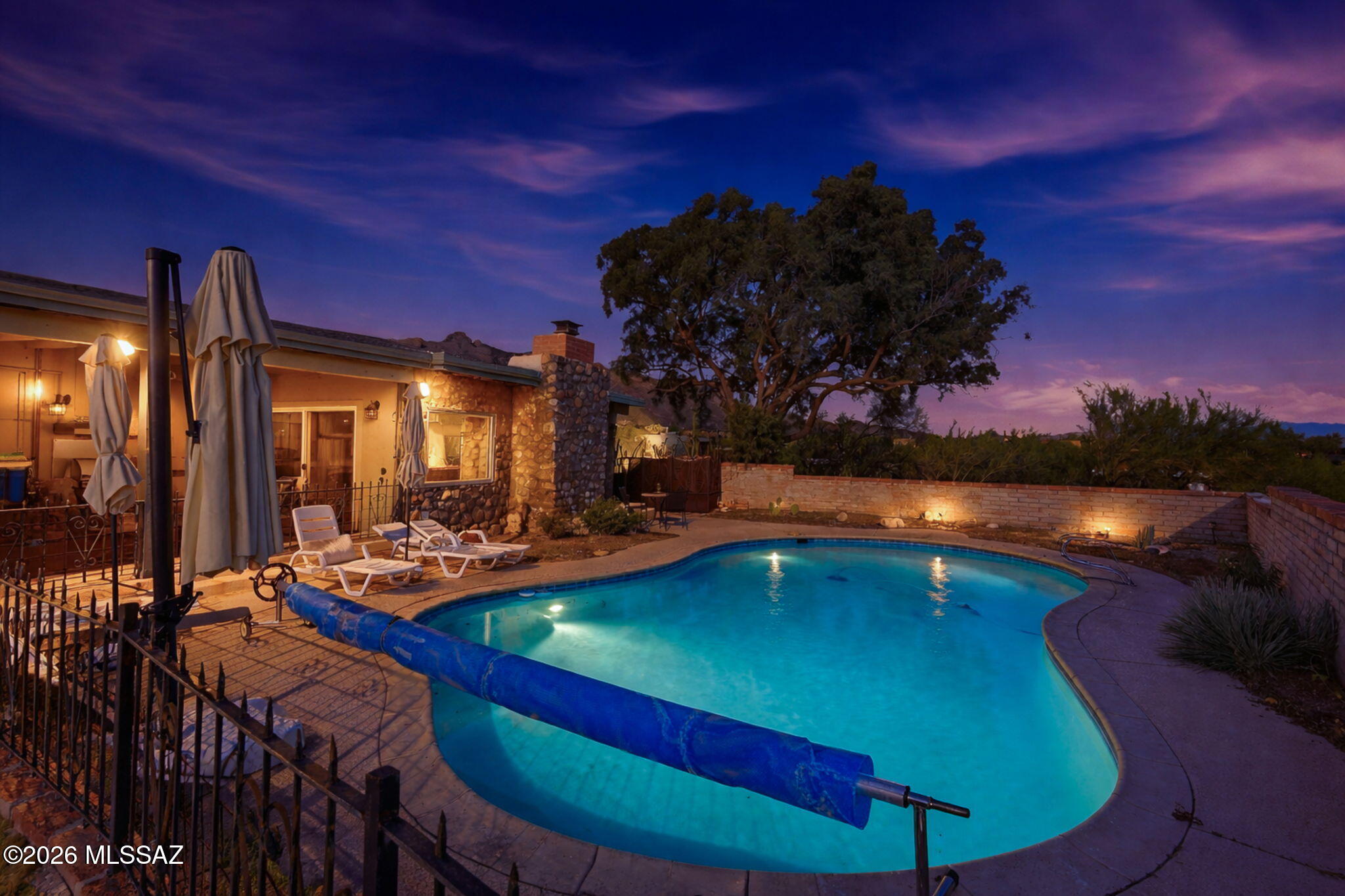 Nestled in the heart of Santa Catalina Estates, this exquisite burnt adobe ranch blends timeless architecture with sophisticated upgrades & views. The spacious 3 bedroom, two bath layout showcases luxury vinyl tile throughout, 5 new sliding glass doors, and two expansive picture windows that frame breathtaking city and mountain views. The living room invites with beamed ceilings and a cozy wood burning fireplace.

The gourmet kitchen is designed to inspire, featuring quartz countertops, sleek fixtures, and full-size drawers for effortless organization. Both bathrooms offer spa inspired serenity. The primary bath boasts a massive walk-in shower, deep soaking tub, and abundant cabinet storage surrounding a quartz topped vanity. The hall bath mirrors this elegance with a shower tub combo, generous cabinetry, and refined finishes.

Bedrooms three allows for flexible living with a partition wall that allows for separation if needed.  These rooms feature new windows and fans, while solid wood doors elevate every bedroom and the refreshed laundry room, which includes a utility sink, cabinetry, and new washer and dryer.

Outdoor living shines with a large, covered patio, built in BBQ, conventional pool, and panoramic views that stretch for miles. The garage includes two 240-volt EV outlets, two extra storage rooms, and a dedicated storage enclave perfect for gear, tools, or seasonal decor.

Additional highlights include a Kind water filtration system, updated lighting throughout, and a RING security suite with five solar powered cameras and doorbell.  Voluntary HOA, Catalina Foothills schools, and minutes from dining and shopping, this home is a rare blend of serenity, style, and smart living