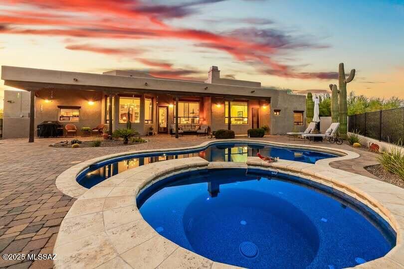 Located in Sunridge in Oro Valley, this 2,888sf, 3 bedroom+den & office, 2 ½ bath home embodies the warmth & spirit of the Sonoran Desert, thoughtfully designed for those who crave the unique character of the Old Pueblo. This custom southwest-style home blends beautifully into the desert landscape while offering authentic design and indoor-outdoor living. Set on a generous cul-de-sac ½ acre lot in the sought-after Oro Valley area, this home draws inspiration from traditional pueblo architecture with hand-carved mesquite entry doors, natural viga beams and scored concrete floors that radiate rustic charm. The den features a classic beehive fireplace, perfect for cozy evenings or quiet reading time. The heart of the home is a spacious chef's kitchen with custom alder and oak cabinetry, granite countertops, stainless appliances & large island w/built-in cooktop ideal for gatherings that flow into the open concept living & dining areas. Retreat to your private primary suite w/its own fireplace & luxurious spa-like bath featuring jetted tub, walk-in shower with dual heads, natural stone countertops & oversized walk-in closet. Outside a pebble-tech pool/spa w/in-floor cleaning, paver stone, fireplace & covered patio w/sunshade. Spacious 3-car garage has epoxy-coated floor & storage room. Low HOA dues are only $140 annually! From fiery sunsets to the scent of creosote after a rain, the Old Pueblo offers a lifestyle like no other and this home captures it perfectly.