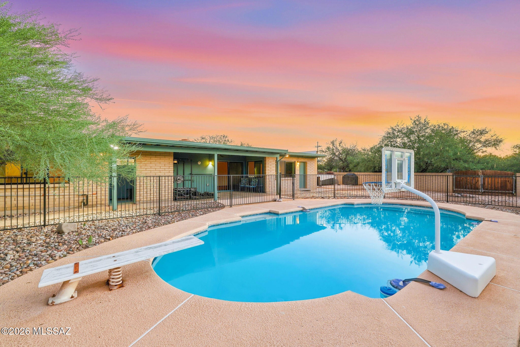 his is THE ONE! Beautiful mountain views, a generous homesite, and exceptional pride of ownership set the tone for this thoughtfully updated Tanque Verde Valley retreat! Framed by mature desert landscaping, this inviting single-level home blends classic Southwestern character with fresh, modern finishes. Cohesive wood-look flooring flows through the living areas and bedrooms, while graceful archways, large picture windows, and abundant natural light create a warm, welcoming atmosphere! Separate living and dining spaces provide flexibility for entertaining, complemented by a spacious family room with a distinctive corner fireplace. The bright kitchen features white cabinetry, stainless steel appliances, and a breakfast nook overlooking the backyard and sparkling pool!
The primary suite offers a comfortable escape with an adjoining sitting area, walk-in closet, and beautifully remodeled bathroom showcasing crisp white tile, striking black fixtures, and a spacious walk-in shower! Equally impressive, the updated guest bathroom pairs warm wood cabinetry and generous counter space with a distinctive black-framed glass shower enclosure. Both bathrooms reflect the thoughtful attention to detail found throughout the home!
The improvements extend beyond the finishes, with replacement windows, updated window coverings, a triple-filtration water system, and updated water lines adding meaningful substance to the home's appeal. An expansive covered patio opens to a sparkling pool and spacious, walled backyard--an inviting setting for outdoor dining, poolside afternoons, and relaxed evenings beneath the desert sky!
Mature trees, beautiful mountain vistas, and room to spread out complete this distinctive property, offering a compelling combination of privacy, tasteful updates, and the indoor-outdoor lifestyle that makes the Tanque Verde Valley so special! Welcome Home!
