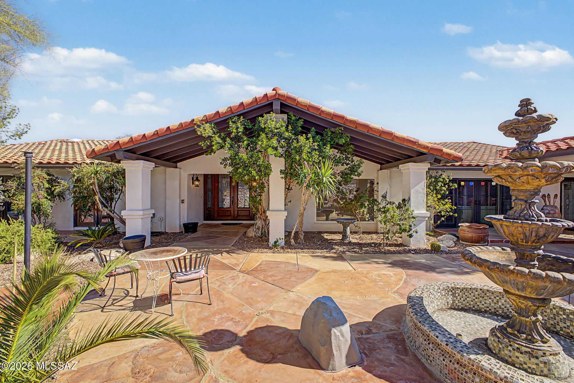 Experience the charm of this remarkable Spanish-style hillside residence at Rockcliff! This elegant home boasts exceptional curb appeal, featuring an RV garage, a 2-car garage, and a spacious gated courtyard with a flagstone floor. Step through custom double entry doors to discover sophisticated design and meticulous attention to detail, with a floor plan thoughtfully centered around the gourmet kitchen. Enjoy a generous formal dining room, elegant wood flooring, tile in high-traffic areas, skylights, and vaulted ceilings. The expansive living room--with multi-sliding glass doors leading to the courtyard and a wet bar--shares a two-way fireplace with the inviting family area, creating a perfect setting to relax and admire breathtaking hill views. The gourmet kitchen offers abundant storage, granite countertops, a custom tile backsplash, a center island, and premium stainless steel appliances. The owner's suite provides outdoor access, a cozy fireplace, and an ensuite bathroom complete with two vanities, a jetted tub, and a spacious walk-in closet. Additional highlights include a large den that can serve as an office or extra bedroom, and a laundry room with a utility sink and generous storage. Step outside to a stunning backyard oasis, featuring an extended covered patio, artificial grass, a fenced pool, and unforgettable sunsets over the mountains. This spectacular home truly has it all!