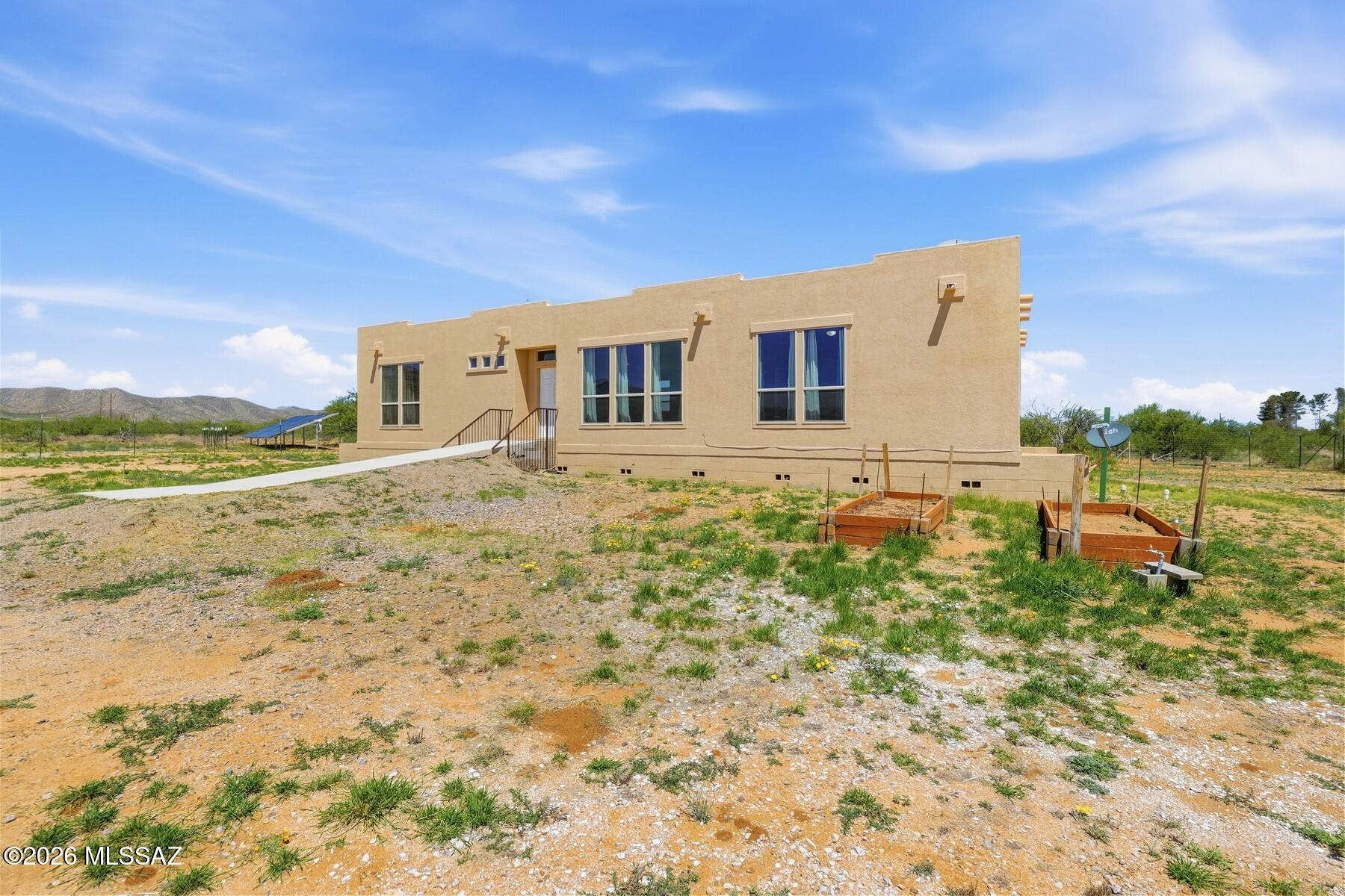 Beautiful home situated on nearly 20 acres with breathtaking mountain views and spectacular Arizona sunrises and sunsets. Inside, you'll find new flooring throughout, spacious bedrooms, and an open concept great room with a desirable split floor plan. Each bedroom features a walk in closet, while both bathrooms offer dual sinks and executive height vanities. The kitchen boasts granite countertops, pull out drawers, and ample cabinetry for storage and convenience. French doors lead to the large primary suite. Additional features include owned solar panels, a private well, two storage sheds, fresh exterior paint, and full perimeter fencing. Enjoy the peace, privacy, and wide-open spaces of country living while taking in the incredible surrounding scenery.