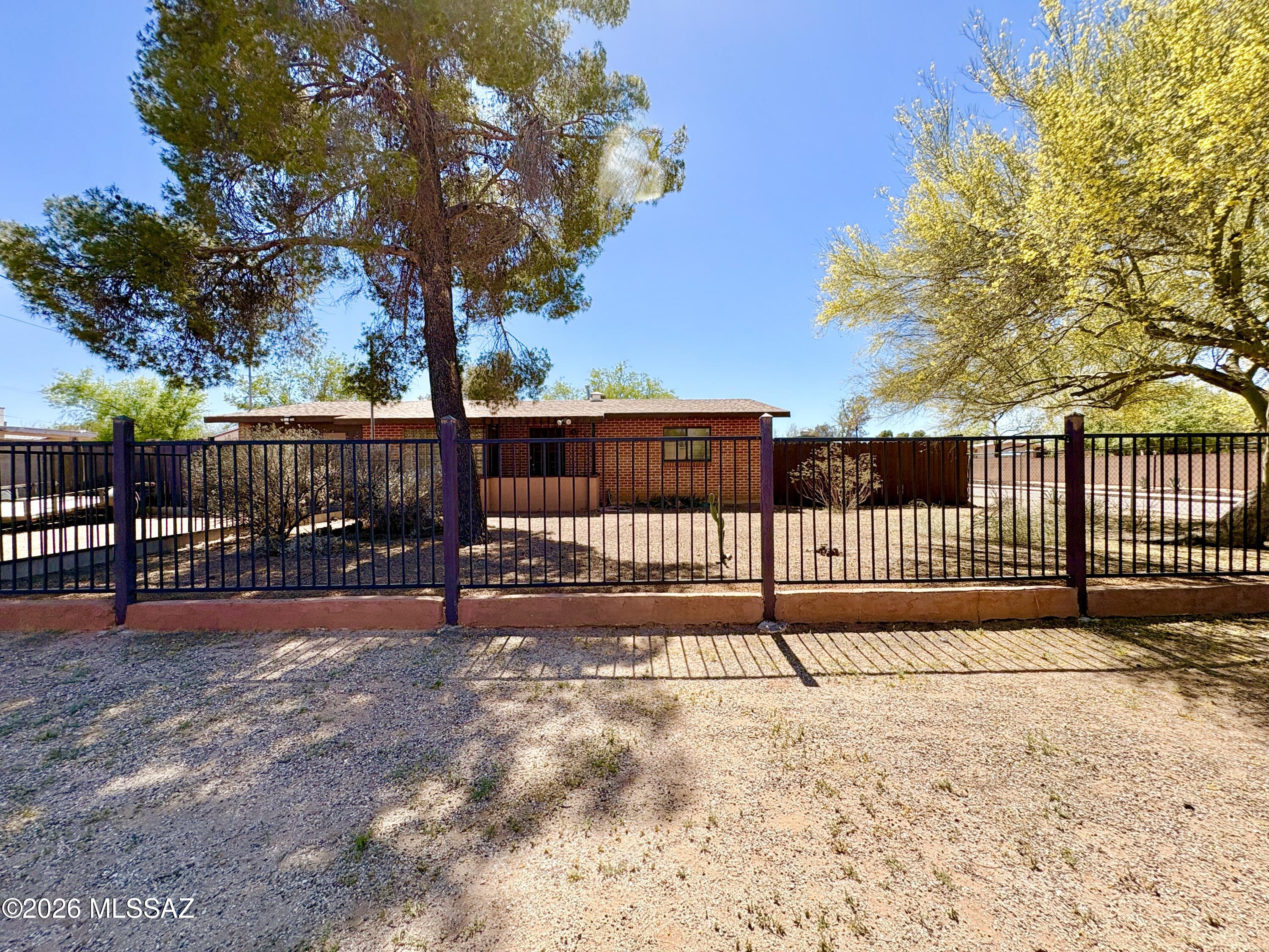 Absolutely stunning, unique, brick house settled on a rare 1/3 acre corner lot is ready for you! HUGE backyard with gated entrance from the left, large enough for a car or work truck! Gorgeous slate flooring elevates the entire home. Kitchen is complete with hickory wood cabinetry, newer stainless steel appliances and breakfast bar. Stylish exposed red brick and access to back patio in the primary suite. Two storage rooms off of porch, one utilized as a laundry room, the other includes extra shelving! Tastefully remodeled bathrooms. Two guest bedrooms are spacious, one has it's own access to a fenced off piece of the back yard! The possibilities are ENDLESS for the huge lot. Build a workshop, garden, pool, casita, you name it! The choice is yours with NO HOA to contend with! Don't miss out on this opportunity to own a hidden gem!