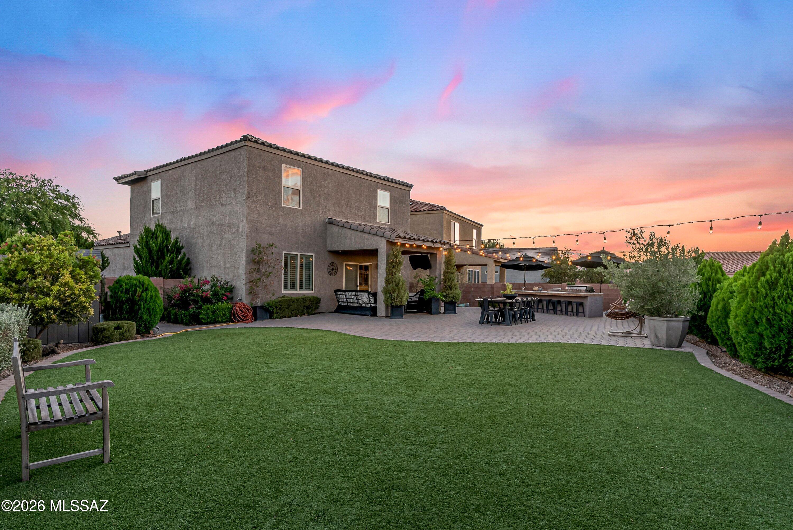 Welcome to this beautifully maintained four bedroom, two and a half bath home with a loft in the desirable Madera Highlands community. A covered front entry opens to a welcoming foyer with a modern stair railing and an open-concept floor plan. The kitchen features rich espresso cabinetry, granite countertops, subway tile backsplash, and overlooks the main living area, making it perfect for everyday living and entertaining.

The downstairs primary suite offers a custom wood accent wall, oversized barn door leading to the ensuite, dual vanities, walk-in shower, and a walk-in closet with custom built-ins. Plantation shutters throughout, a downstairs laundry room with storage cabinets, and three additional bedrooms with a spacious loft upstairs provide both comfort and functionality. The true showstopper is the backyard, one of the largest lots in the neighborhood! Designed for entertaining and enjoying Arizona living, it features an extended paver patio that wraps around both sides of the home, a large turf area, built-in outdoor kitchen with barbecue, café lighting, mature privacy hedges, and stunning mountain views. Whether you're hosting friends or relaxing under the open sky, this outdoor space is truly a dream.

Additional highlights include a 2-car garage with epoxy flooring and built-in storage cabinets, making this home as practical as it is beautiful.