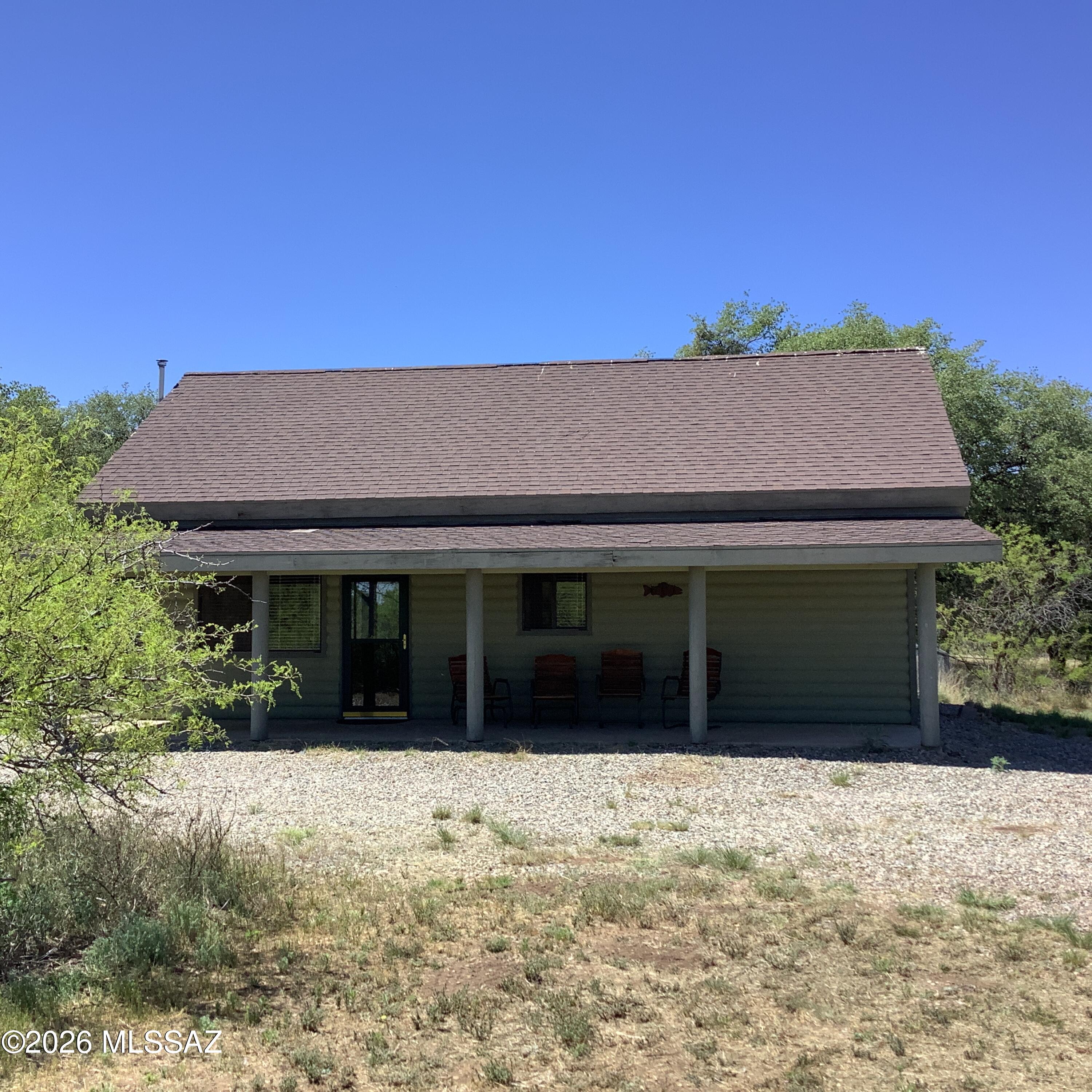 Beautiful furnished Log Cabin with a roomy loft and detached garage. Talk about views from the covered porch, this cabin sits at the foothills of the Chiricahua Mountains and boarders Rock Creek which runs seasonal.  Mature forest trees, plenty of wildlife just about 5000' elevation.  You would not think 718 sq feet was big but there is nice size living room with pellet stove, separate dining area and a breakfast bar, full bathroom with tub/shower combo and laundry.  Primary bedroom has large closet, sliding door to fenced in back yard, and view of the creek. The loft is a great place for games, office or an extra sleeping room. Fantastic view of the neighboring vineyard from window.