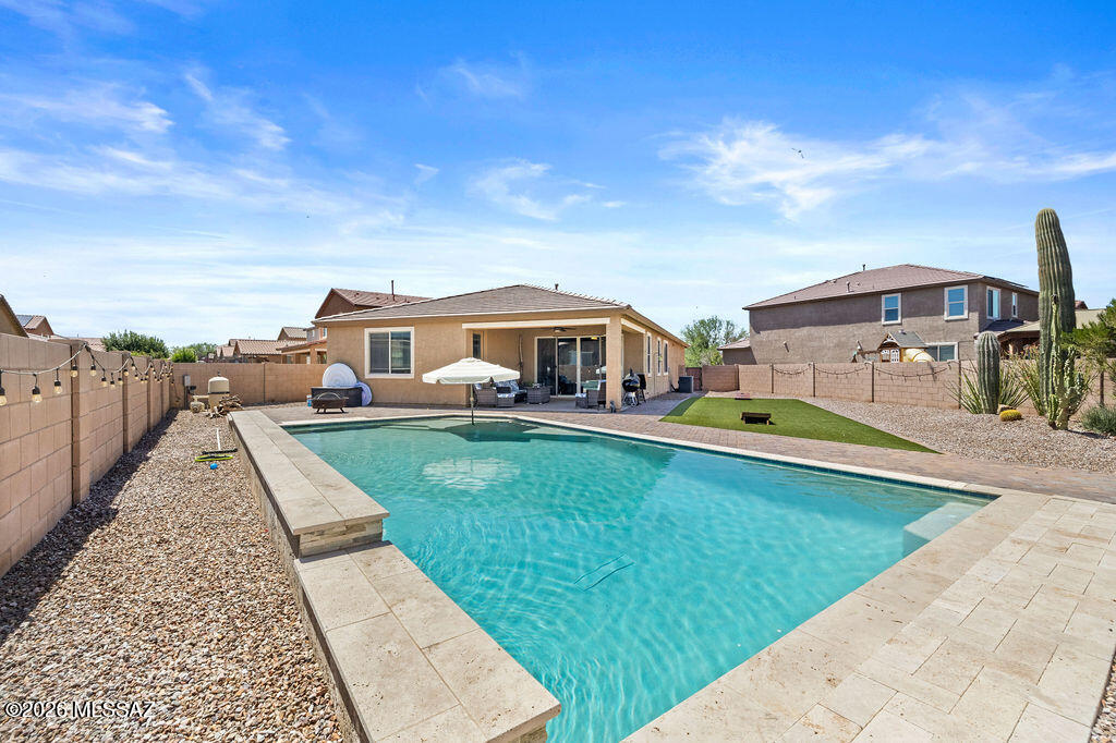 This entertainer's paradise has a resort style pool complete with 3 waterfalls and it sits on one of the largest lots in the neighborhood! 4.75% VA assumable loan available for qualified veterans. Large tile flooring sprawls throughout all living areas of the home, while every countertop is beautifully upgraded granite. The large primary suite has a barn door leading into the primary bathroom, which features a tile surround walk-in shower. There is also a robust solar panel system, which the seller is willing to pay off with an offer at the top end of the range. The spacious garage has epoxy floors. The La Estancia neighborhood features pickleball courts, parks, pools and more. Situated in the Vail School District & just minutes from Davis Monthan & the I-10, this location is truly ideal!