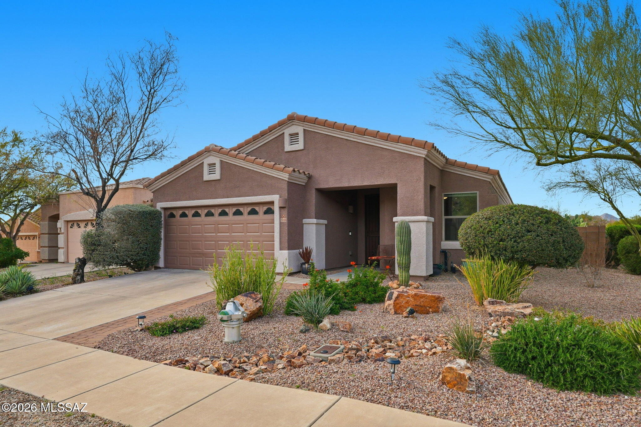 Experience the pinnacle of Oro Valley living in this tastefully updated 3-bedroom, 2-bathroom home situated in the sought-after Ram Pass neighborhood. Boasting a fresh exterior repaint and mature desert landscaping, this home makes a striking first impression on its expansive corner lot. Open split floor plan features modern light fixtures and contemporary ceiling fans throughout. Primary bedroom features two walk-in closets, updated bathrooms with dual vanities. The kitchen is anchored by an oversized granite peninsula designed for hosting and entertaining. A versatile added den provides the ideal space for a quiet home office or a flexible media room. Just steps away, the Ram Pass community features premier amenities, including basketball court, scenic walking paths, and a park.
