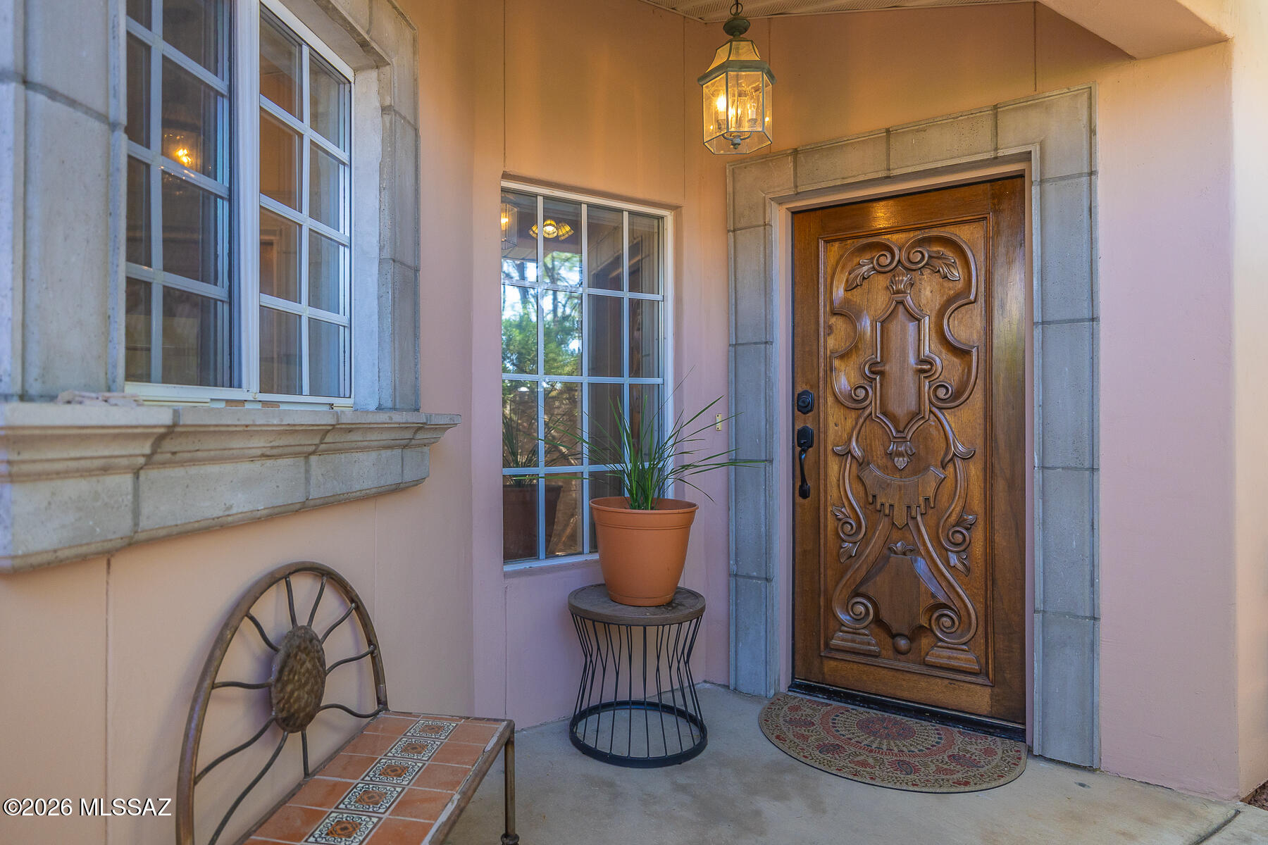 Located in a small gated community near Skyline and Swan, this townhome offers privacy and charm. A front gate opens to a walled yard w/lush greenery and access to the backyard which features a large patio w/cement columns and peaceful, soothing fountains. Inside, enjoy the spacious great room w/bamboo floor, 9 ft ceilings & fireplace. Kitchen features granite tile counters, custom cabinetry and a sunny breakfast nook w/mountain views. Lighted niches line the hall for art displays. 2 bedrooms plus a private den. Spacious primary suite has plantation shutters and a walk-in closet. Second bedroom has a built-in wall bed and desk. Home has recent A/C, 2 car garage w/ample storage, epoxy floors and ample storage. Enjoy Catalina Foothills living near shopping, dining, and hiking trails.