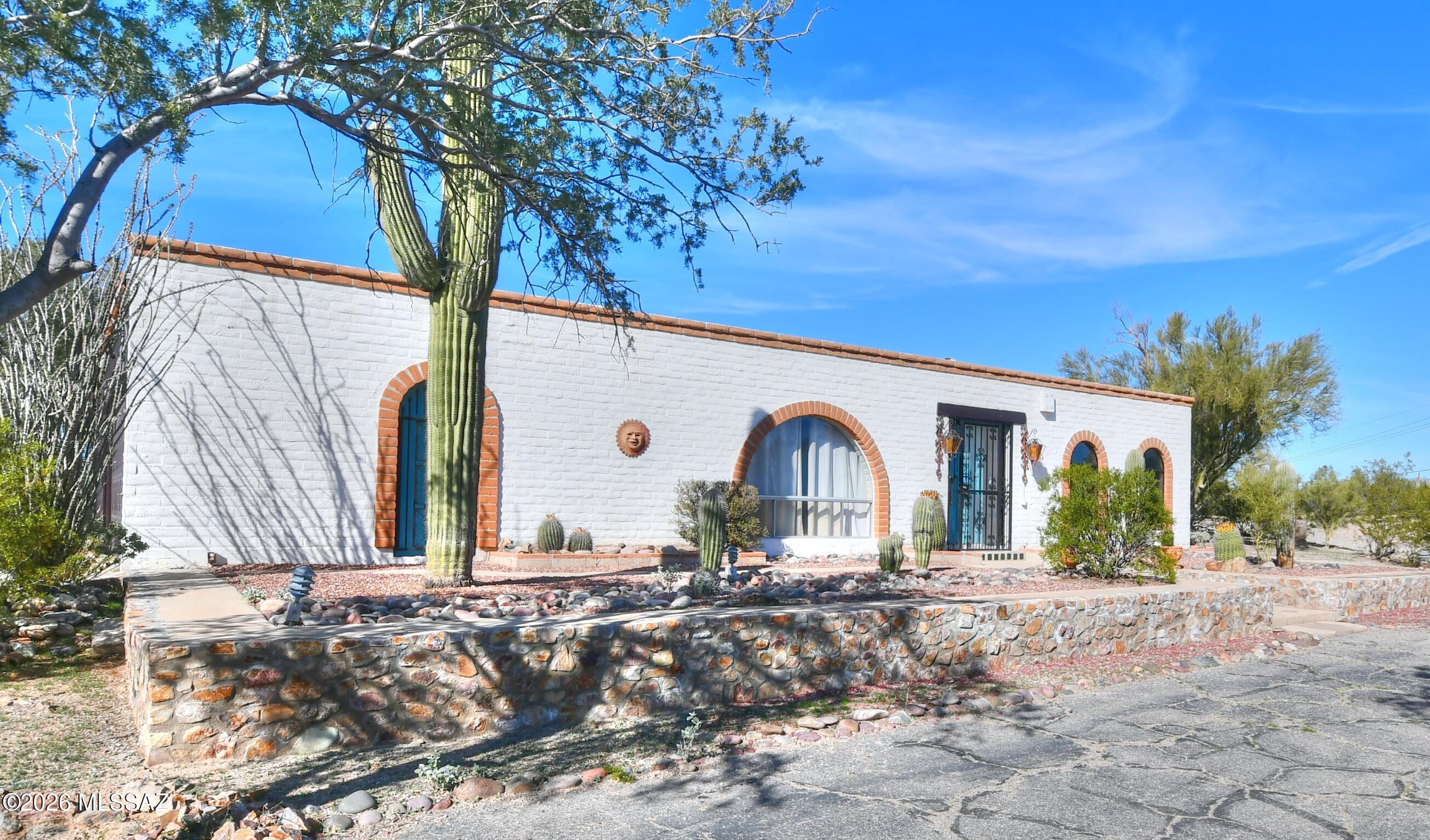 Rare opportunity - first time on MLS.  Close in horse ranch on 8.64 acres.  Original owner,  4 bedroom 2 bath custom home sitting high on a hill with 360 degree views.  New carpet in bedrooms.  Great screened in porch with kitchen pass through.  Masonry horse barn with covered carport for horse  trailer or RV, large, fenced arena, tack and feed rooms.  Property served by private water well.  Marana R144 is the current zoning, property is dividable.  Located at a major intersection, property may offer other uses or future rezoning options, check with the Town of Marana.   All photos with furniture are Virtual Staging.