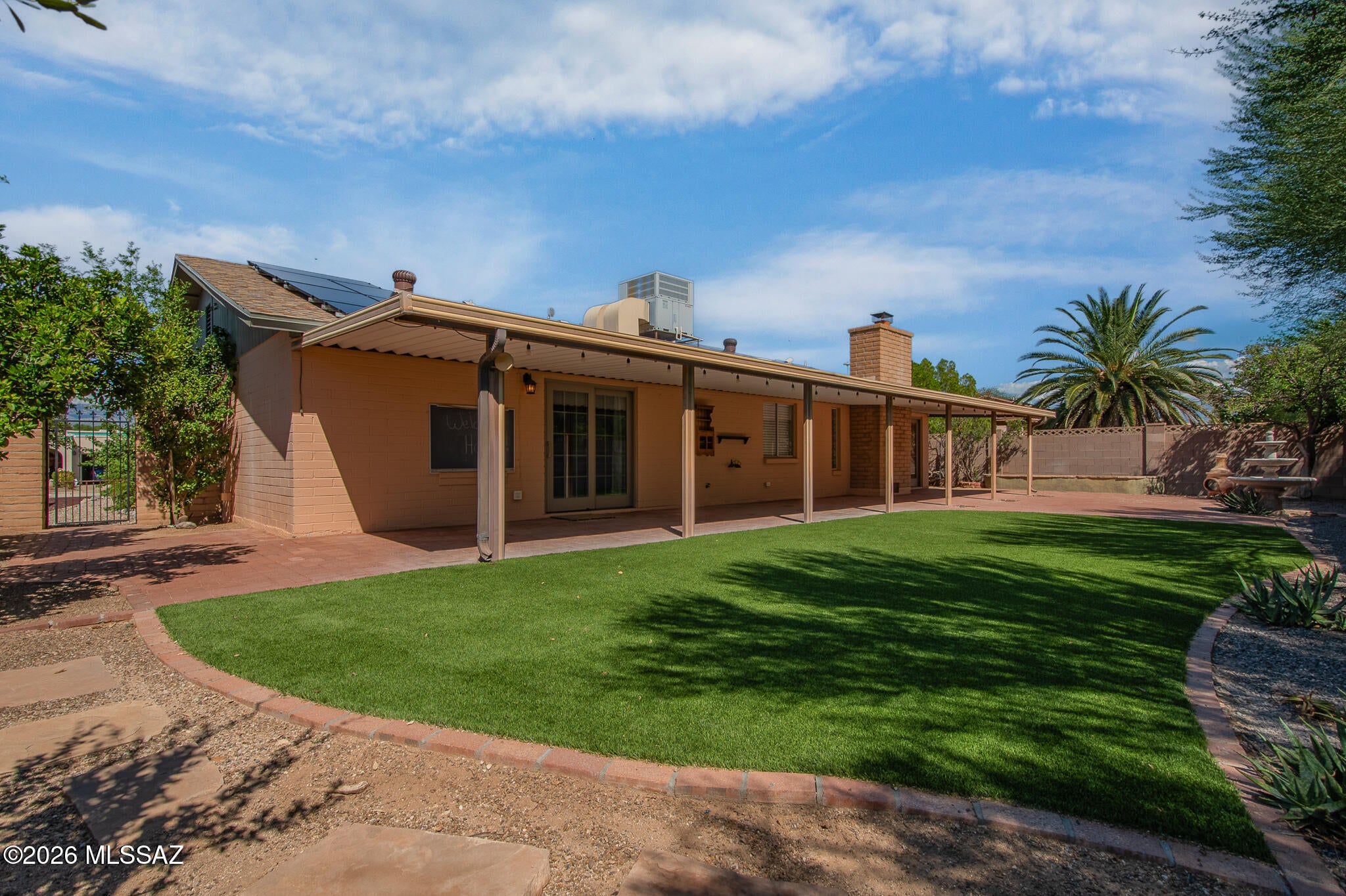 Welcome to this beautifully appointed 4-bedroom, 2-bath home, featuring exceptional curb appeal with beautiful landscape and a charming courtyard entry that creates an inviting first impression. Stylish and quality renovations include elegant granite countertops, rich cherry cabinetry, beautiful ceramic tile flooring, and a cozy wood-burning fireplace. Enjoy the beautifully landscaped backyard with artificial turf, fruit trees, desert landscaping, brick patio, and an expansive covered porch,  a peaceful and private setting for relaxing or entertaining with no neighbors behind. Modern conveniences include owned solar, a newer HVAC system, and an EV-ready garage. Nestled on a peaceful street in a  desirable neighborhood, this exceptional home is truly move-in ready!