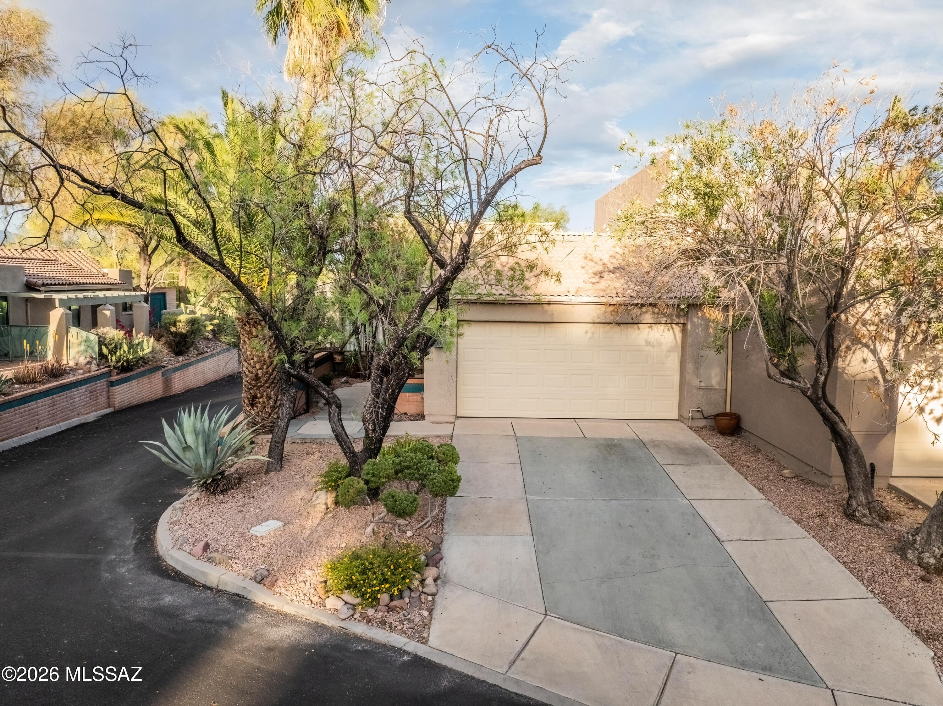 Exquisitely, move-in ready all-electric 1,380 sq. ft. single-story end unit nestled in the highly sought-after Starr Pass community. This 2 bedroom/ 2 full bath is thoughtfully designed with a desirable split floor plan, this residence showcases a new roof, timeless Saltillo tile, and rich engineered bamboo flooring, complemented by security doors for added peace of mind. The expansive primary suite offers a private retreat with dual vanities, generous walk-in closets, and direct patio access. Multiple access points from the kitchen, living room, and primary suite create a seamless indoor-outdoor living experience. Soaring ceilings and ceiling fans enhance the home's open, airy ambiance. The inviting living room is anchored by a charming wood-burning fireplace and wet bar, ideal for both relaxing and entertaining. The home is equipped with a water softener system and reverse osmosis in the kitchen for added comfort and convenience. Perfectly positioned less than 5 miles from downtown Tucson, with convenient access to the University of Arizona, Pima Community College West, the renowned Starr Pass Marriott Resort, and I-10