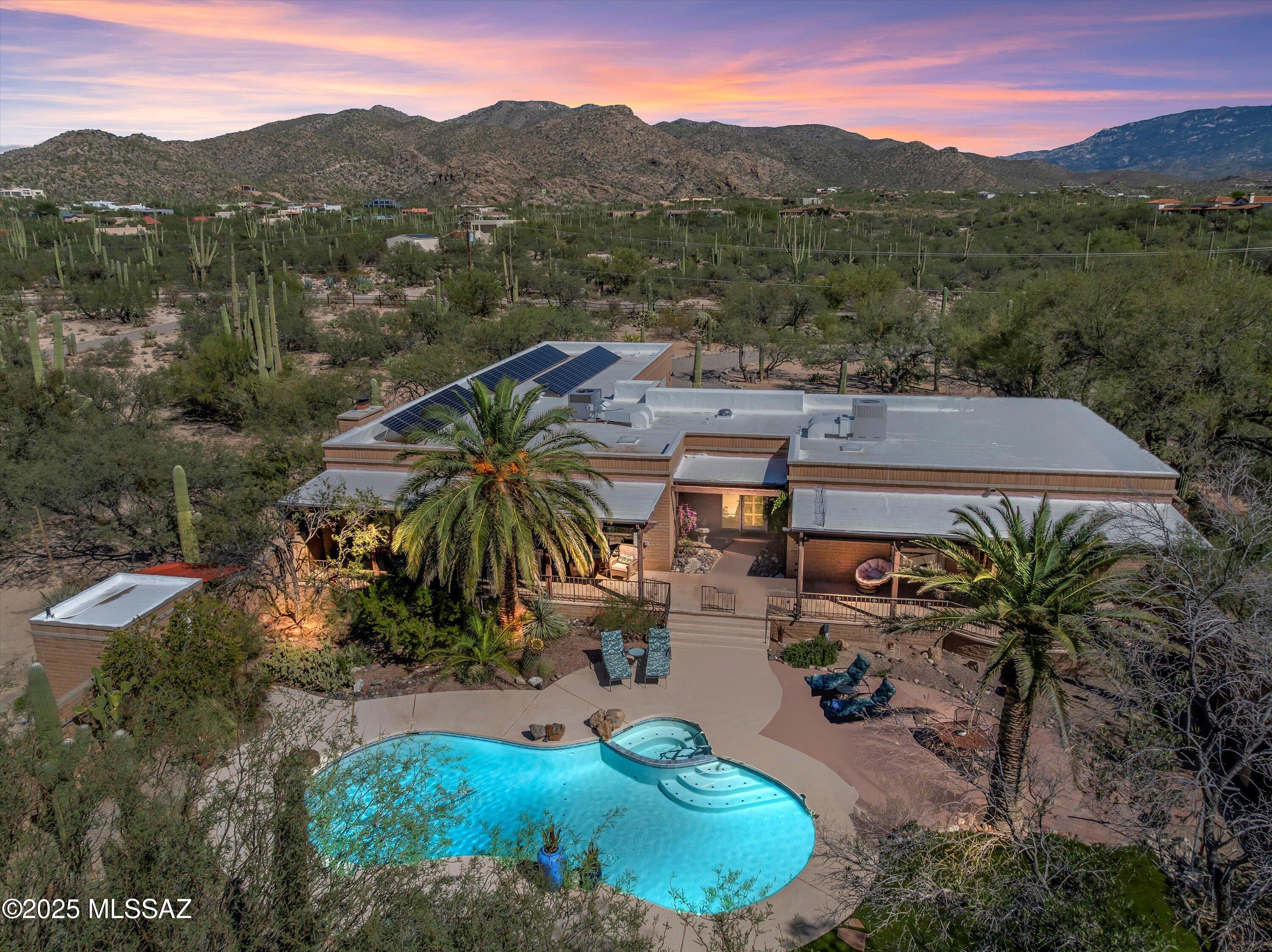Welcome to Your Desert Estate at 3825 N Silver Drive. Discover a truly sacred space where history, nature, and luxury converge on this magnificent 3.37-acre estate in Tucson's coveted Tanque Verde Valley, one of the area's most desirable locations. This exceptional 3,555 square foot, 4-bedroom, 3-bathroom Territorial Santa Fe-style Ranch Estate with a pool and equestrian facilities showcases timeless Southwestern architecture—the kind of solid, masterfully crafted construction with authentic details they simply don't build anymore. Perfectly positioned to capture breathtaking panoramic views of the Catalina Mountains framed by towering palms, pool, and the most spectacular desert sunsets you'll witness.
Step inside to discover a home that captures the true essence of Tucson living. The warmth of traditional exposed wood vigas, authentic Saltillo tile floors, and seamless indoor-outdoor flow create an atmosphere that feels genuinely, unmistakably Tucson. This isn't a house trying to be somewhere elseit's rooted in the desert, embracing the landscape and lifestyle that make Southern Arizona special. The updated U-shaped kitchen features quartz countertops, stainless steel appliances, a spacious pantry, abundant cabinetry, and a breakfast bar opening to the breakfast nook. Natural light pours in through windows and skylights throughout. The spacious formal dining room and family room offer perfect spaces for entertaining, featuring a striking stone fireplace and wet bar ready for margaritas at sunset and gatherings with friends and neighbors. A dedicated office and media/den area provide flexible space for work and relaxation.
The thoughtful split bedroom L-shaped floor plan includes a luxurious primary suite with its own private sitting room opening to a west-facing patioyour personal front-row seat to those legendary desert sunsets. The primary bath features three sinks including a double vanity, a walk-in shower, and dual walk-in closets. Multiple expansive covered patios create seamless flow to the west-facing backyard oasis, where mature desert landscaping and established shade trees frame the inviting pool. As evening approaches, gather around the custom fire pit surrounded by majestic saguaros, where the desert comes alive under a canopy of stars. Listen to horses neighing softly in their paddocks, coyotes singing in the distance, and the gentle rustle of desert breezes through the palms. Watch the sky transform into brilliant shades of orange, pink, and purple against the silhouette of the Catalinas. Energy-efficient solar panels provide cost-effective power for your desert lifestyle.
Wildlife enthusiasts will be enchanted by daily visitorscolorful birds, playful squirrels, graceful deer, and even bobcats coming to drink from the pond. Horse lovers will appreciate the equestrian facilities including a 4-stall barn, three paddocks, a professionally lit arena, horse washing stand, and separate hay and storage barns, with direct access to ride from your property to Agua Caliente wash and trails. Cycling enthusiasts will love the close proximity to the Mount Lemmon Highway for world-class road biking. The Territorial Santa Fe-style courtyard with circular driveway creates an inviting entrance, while the convenient side-loading garage completes this remarkable estate.
Built to stand strong for generations and lovingly maintained by only two owners over nearly 50 years, this home offers something truly extraordinaryit's a sanctuary built upon the ancient Tohono O'odham settlement, part of the University of Arizona's Whiptail Ruins archaeological study. Indian pottery shards still emerge from the earth, connecting you to centuries of heritage and the warm waters of nearby Agua Caliente. Located just steps from Agua Caliente Park in the heart of Tanque Verde Valley, this is where the timeless spirit of the desert creates an unmatched living experience.
Call us today to schedule your private tour.