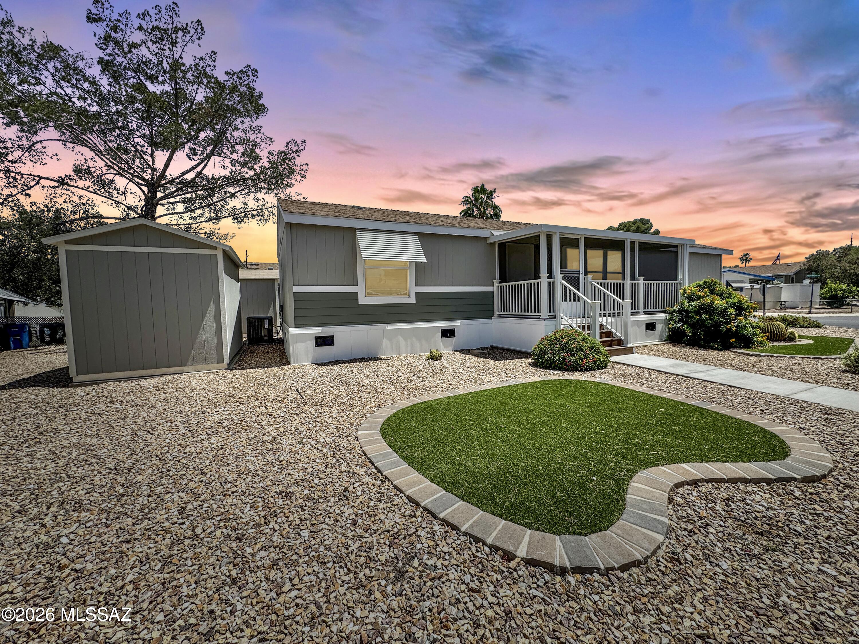 MUST SEE gorgeously upgraded 2025 3 Bd 2 BA Cavco Berkley double on a Premium corner lot with mountain views, located in highly desirable, access controlled 55+ Tucson Meadows. Over $46k in upgrades! EZ care 26 mil commercial grade LVP flooring throughout eliminates trips & keeps feet happy! The lovely kitchen has upgraded cabinets, stainless appliances. Walk-in & 2nd closet in primary w/FOUR tall 24x24'' pantry cabinets for extra storage. Keep cool w/shade awnings over bedroom windows & enjoy carefree mornings socializing from your screened-in front porch.  Enjoy outdoor shade under a 3 car tandem carport w/sunscreens running the full length. Over 200 sqft of outdoor storage w/2 8x12 tuff sheds each w/mini-splits and set on concrete slabs. This is luxury retirement living at it's finest! With so many activities, this community features clubs, exercise facilities, dinners and social events, community laundry, RV parking, fenced dog park, shuffleboard, community pool & spa. Enjoy special rates at the super fun and slightly challenging Rolling Hills par 63 executive golf course 0.2 miles away, or enjoy a bike ride or walk along the loop bike path just outside the neighborhood. Close to shopping, restaurants, and groceries, and within 15 minutes of numerous other golf courses, national parks, downtown, and so much more!