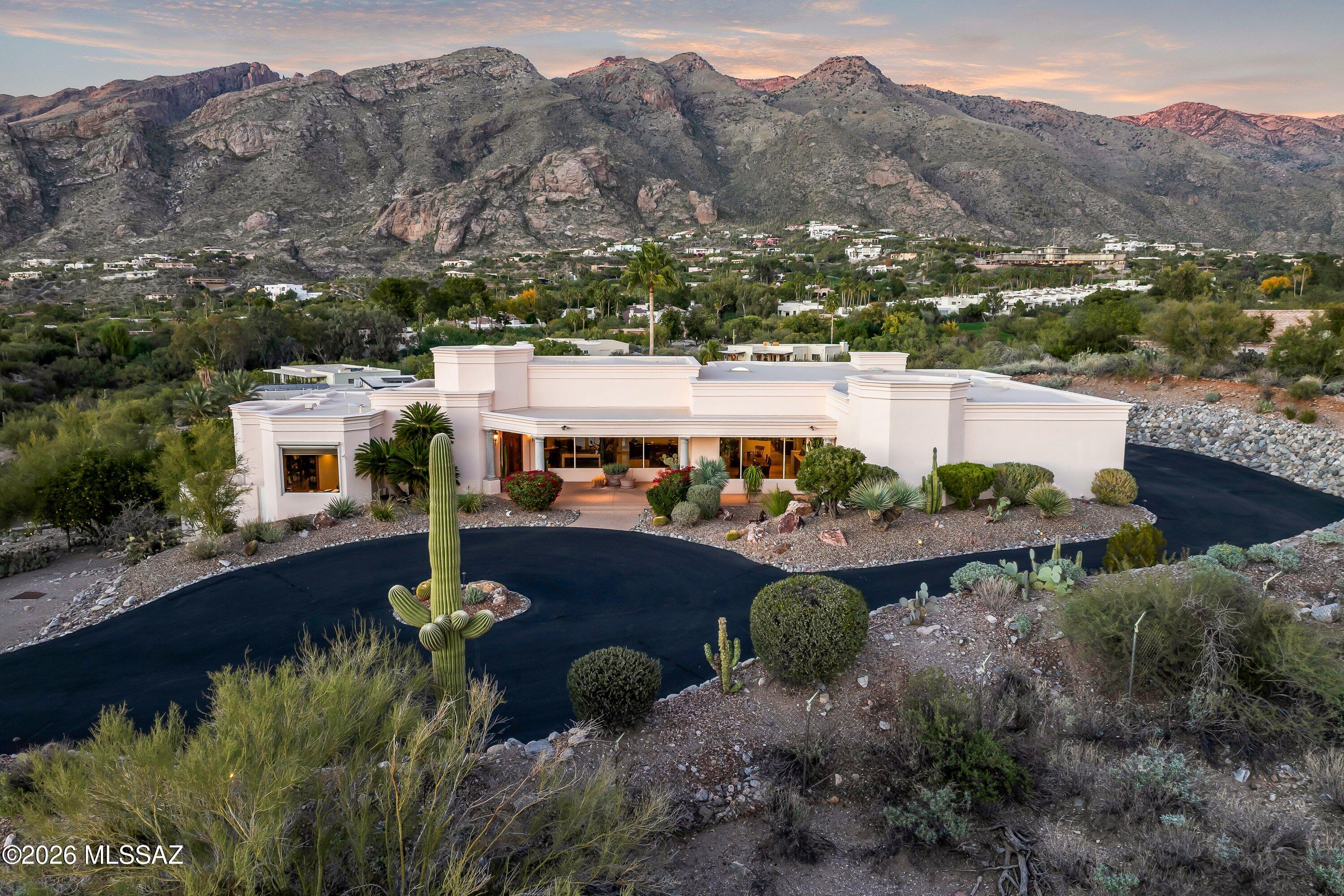 Tucked behind the gates of Skyline Country Club, this custom contemporary residence offers exceptional privacy and truly breathtaking mountain and city views. Thoughtfully designed for both refined living and effortless entertaining, the home features three bedrooms plus a versatile den, ideal for a home office, media room, or additional guest space.
The spacious eat-in kitchen is the heart of the home, designed for gathering—whether hosting friends, cooking with family, or enjoying quiet mornings framed by stunning desert vistas. Clean architectural lines, generous living spaces, and an intuitive floor plan create a home that feels both sophisticated and welcoming. Meticulously maintained, the residence reflects pride of ownership throughout. Perfectly positioned with easy access to golf and tennis at Skyline, world-class hiking, and the boutiques and dining of La Encantada, this home places you moments from the very best of Tucson living. Located in a UNESCO City of Gastronomy, the surrounding area offers an extraordinary culinary scene to match the lifestyle. A rare opportunity to own a private, view-rich contemporary home in one of Tucson's most coveted country club communities.