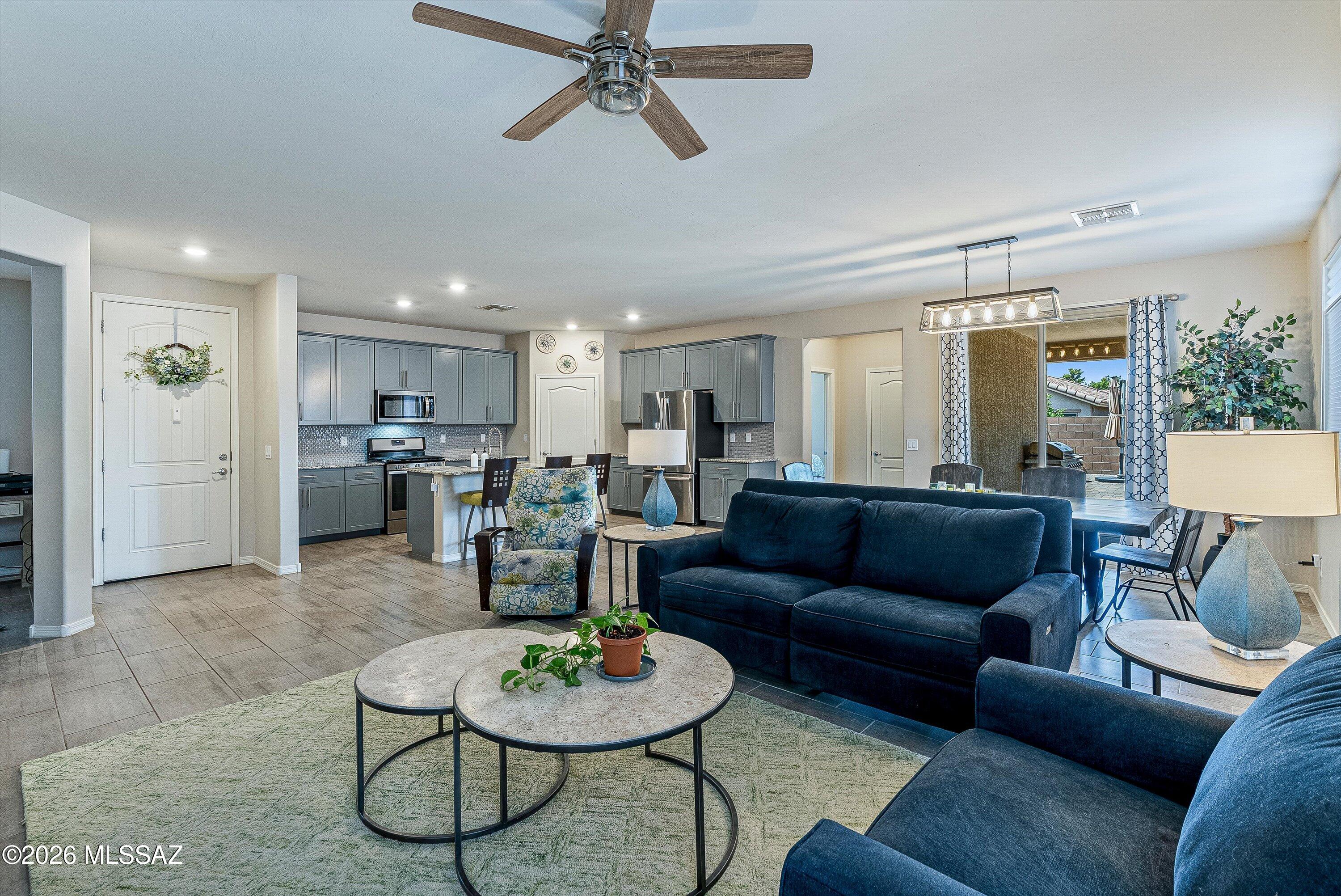 This single-story home features a 1,740 square-foot split floor plan in a gated community. Stone-accented facade and paver driveway lead past native desert plantings to the front door. The tiled foyer ushers you into an open concept great room that provides line of sight for all the areas that are the heart of the home. Kitchen finishes include blue-grey shaker cabinetry, granite countertops, a gas range, and a stainless steel farmhouse sink. A dedicated den is just off the foyer, with two secondary bedrooms, and the primary suite on opposite sides of the home. Sliding glass doors open to a neat and spacious low-maintenance backyard designed with a covered patio, an extended paver terrace, and artificial turf. You'll be tucked away yet convenient to schools, shopping and restaurants.