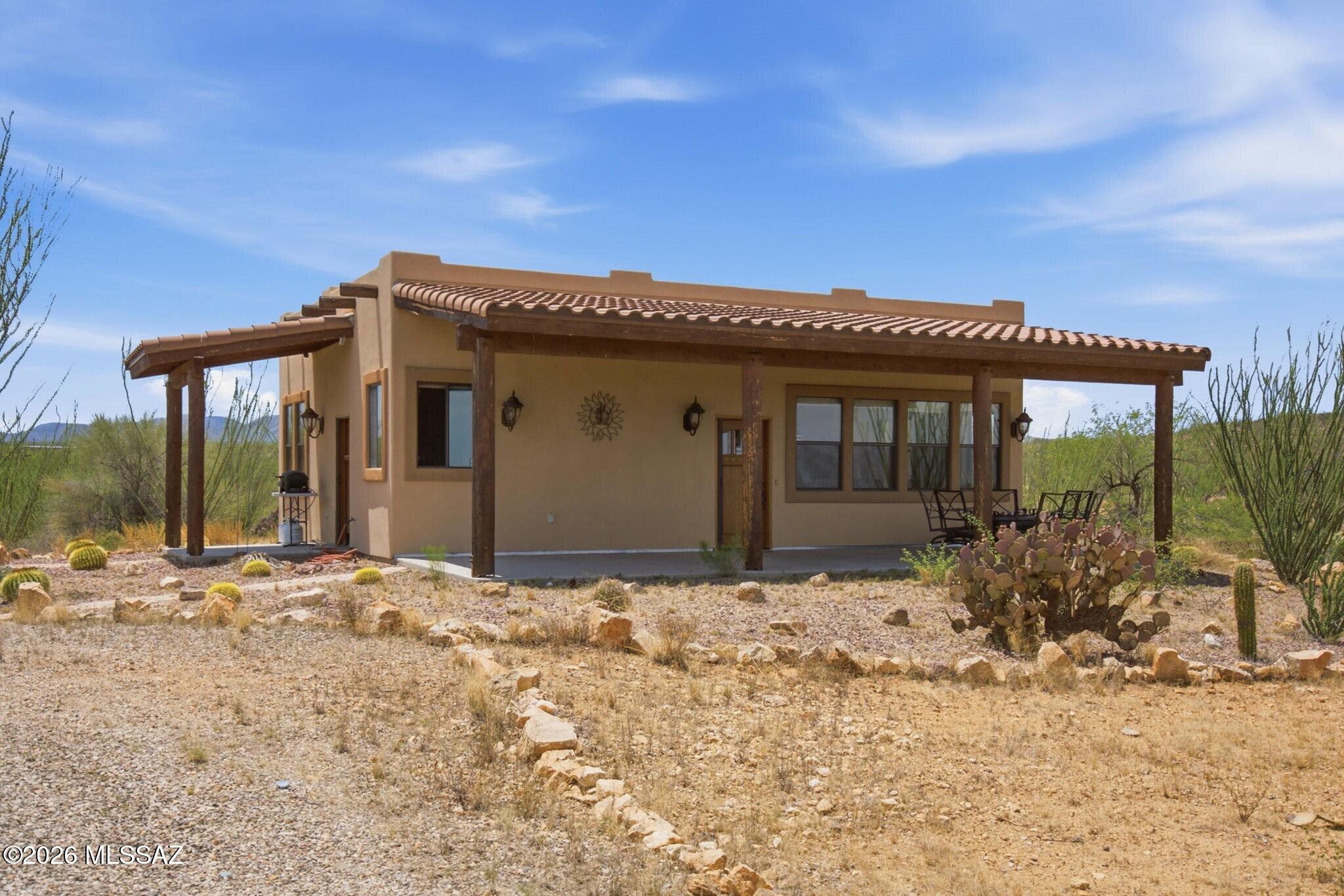 Tucked away in the desirable Wrangler Ranch community, this gated 8.7-acre retreat offers sweeping mountain views, exceptional privacy and direct access to the beauty of Southern Arizona. Backing to state land, the property enjoys an expansive natural backdrop where open skies and rugged desert scenery provide the setting for everyday life. Large windows frame the landscape, while the open-concept floor plan makes it easy to relax or entertain. Here you'll find two spacious bedrooms, each with its own ensuite bathroom, providing a comfortable space for owners and guests alike. Covered porches create the perfect place to enjoy morning coffee, watch spectacular sunsets or simply take in the peaceful surroundings. Detached garage offers ample space for vehicles, hobbies and outdoor gear.
