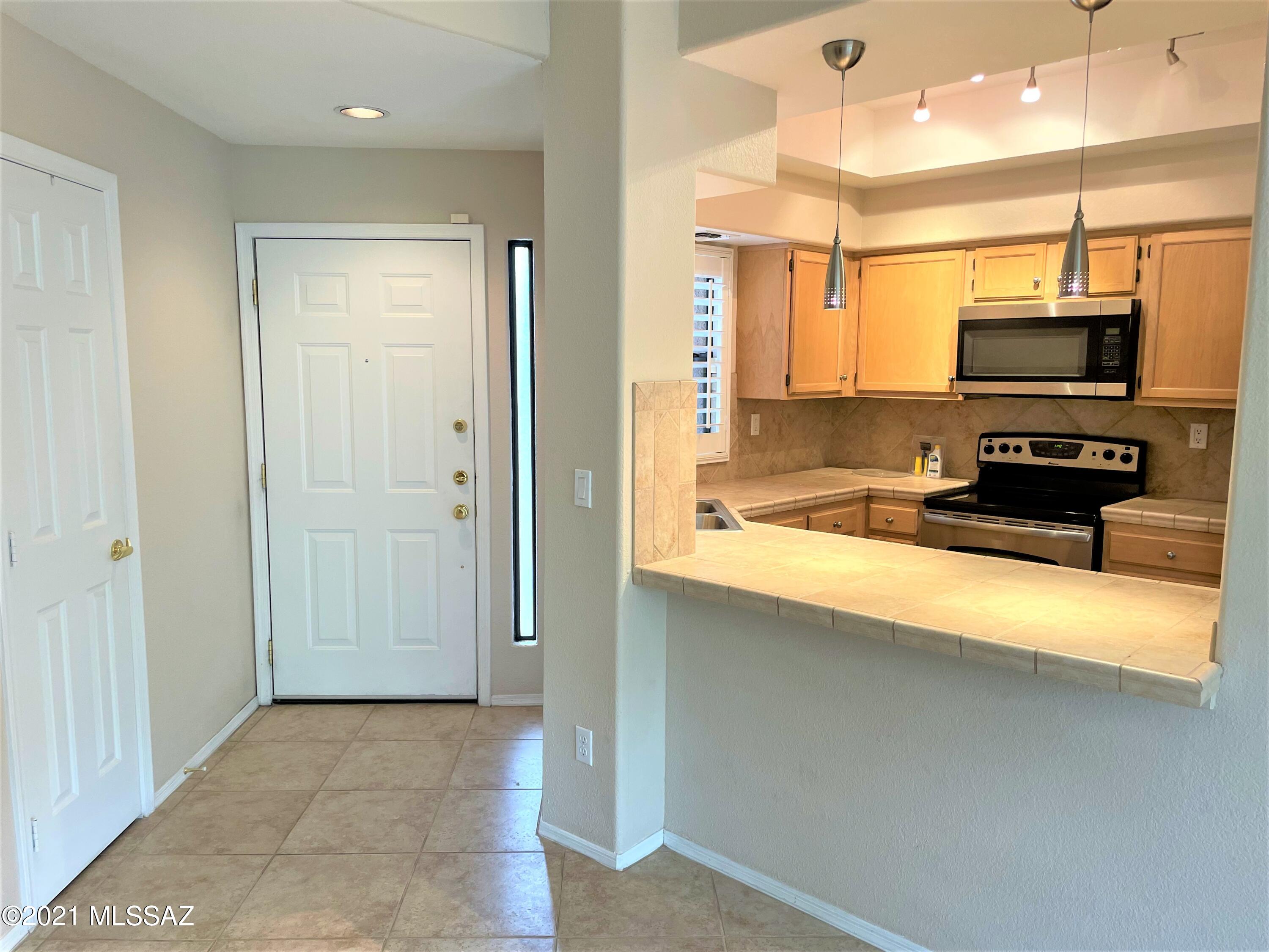 Gorgeous ground floor condo at Canyon View at Ventana Canyon. This updated and upgraded home features Tile everywhere but the bedrooms, fireplace, shutters, fireplace, ceiling fans etc! You cant miss the unbelievable mountain and desert view from your great room, and spacious screened in private patio. Kitchen features plenty of cabinet space, tile counter tops, stainless steel appliances and breakfast bar. Perfect split floorplan, the Owners suite featuring a huge walk in closet, and a separate shower and vanity area. Also you own private entrance to the balcony. Second bedroom also features a walk in closet. Second bathroom includes a tub/shower combo. Washer and Dryer are also included. Welcome  home!