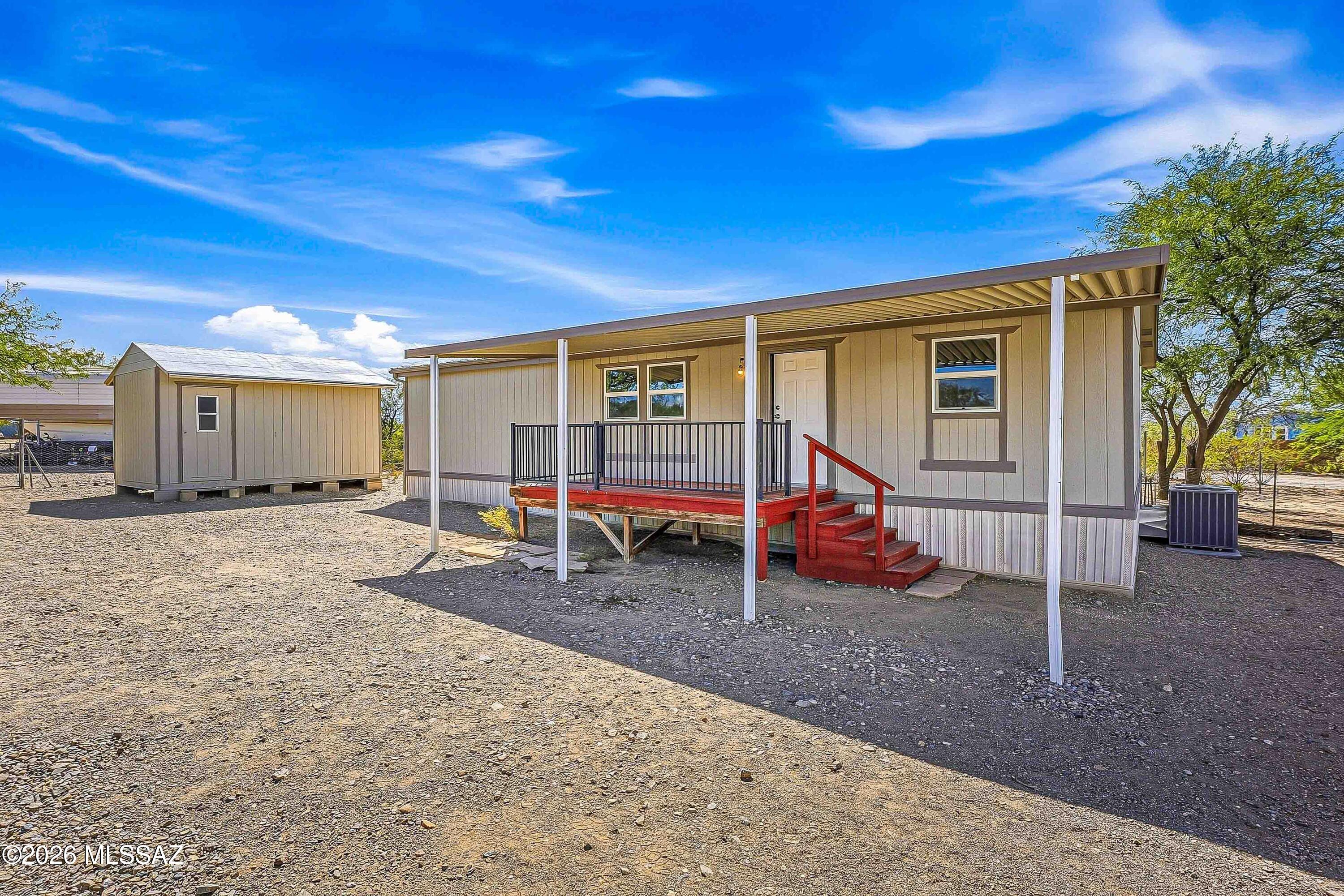 Looking for space, privacy, and room to spread out? This 1998 manufactured home sits on a generous 4.14-acre lot with NO HOA! Offering 1,344 sq. ft. of living space, this 3-bedroom, 2-bath home features a desirable split-bedroom floorplan, providing added privacy between the primary suite and secondary bedrooms. Enjoy beautiful mountain views from the large covered porch and appreciate the peaceful setting at the end of a paved road. The home has seen several valuable updates, including a brand-new metal roof, all-new dual-pane windows, and newer ductwork with an A/C unit installed in 2021. All laminate flooring throughout offers easy-care living. Need room for hobbies, projects, or extra storage? The detached workshop is approximately 12' x 20' and is ready for your ideas! 
Four covered detached carports provide plenty of covered parking, plus there is a small enclosed container sized for a golf cart or additional storage. The property is served by a private shared well with 9 users and features enclosed fencing surrounding the front of the property. With acreage, mountain views, useful improvements, ample covered parking, and the freedom of no HOA, this property offers an opportunity to enjoy a more independent lifestyle with room for your vehicles, equipment, hobbies, and outdoor plans. Come explore the possibilities!