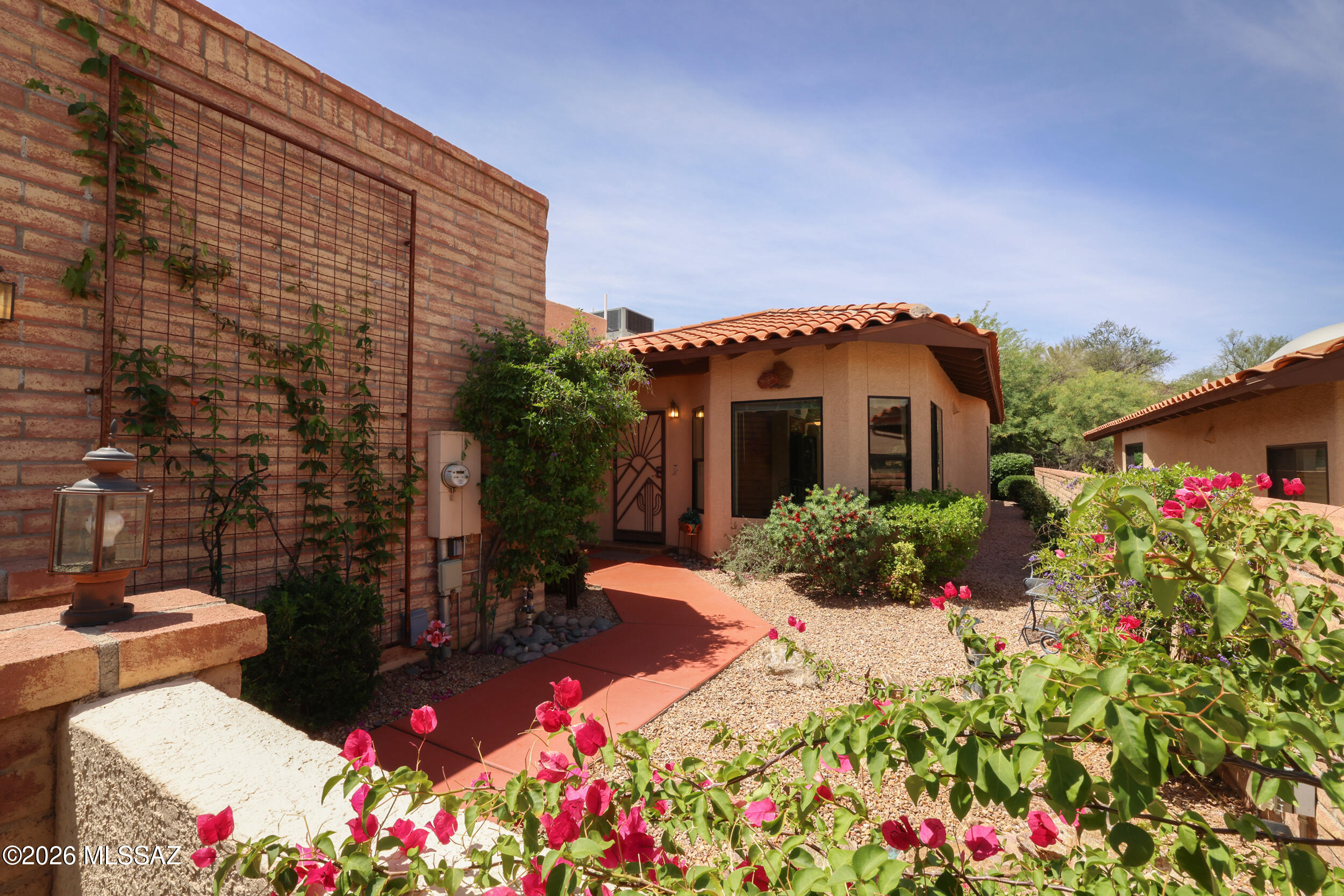 Enjoy resort living in this stylish updated townhome in highly sought after Valle del Oro Townhomes near Oro Valley Country Club. Lovingly maintained and move-in ready with beautiful updates throughout. Bright, kitchen features breakfast nook with mountain views, upgraded cabinetry, granite counters, stainless appliances, gas range & a window opening to the living/dining areas. Spacious, light-filled living spaces. Primary suite offers patio access, updated bathroom with large tiled shower, dual vanities & walk-in closet. Inviting guest bedroom with updated guest bathroom.  Inviting courtyard entry with rock waterfall for ambiance. Immaculate 2-car garage with built-ins & workbench. Low care backyard/patio. Turn-key opportunity with furnishings included. Community pool & rec center.