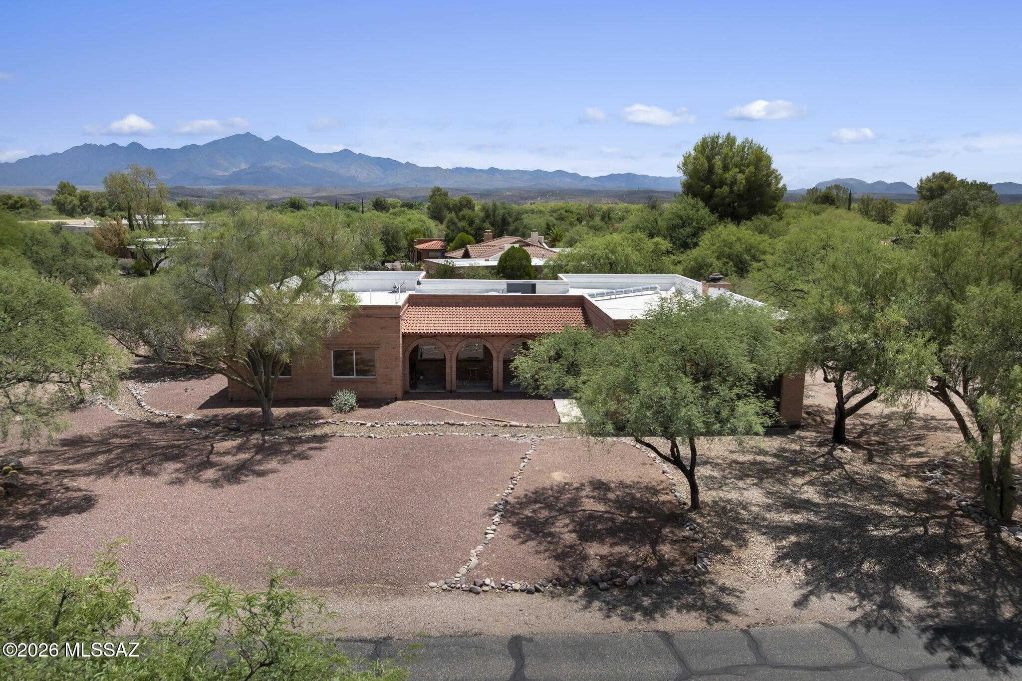 Nestled on more than half an acre in the desirable Tubac Valley Country Club Estates, this beautifully maintained 3-bedroom, 2-bath home delivers the relaxed Southwest lifestyle you're craving. Thoughtfully designed for both everyday living and entertaining, the home's open-concept interior layout flows effortlessly into an exceptional backyard retreat, framed by panoramic mountain views. Cool off in the sparkling pool, gather around the built-in fire pit on crisp desert evenings, or host unforgettable cookouts at the built-in BBQ. Interior design features include roomy gathering space and private primary suite with walk-in closet and spa-like en suite bath. Generous lot offers room to grow, with ample space to add a detached casita for guests, a home office or multigenerational living.