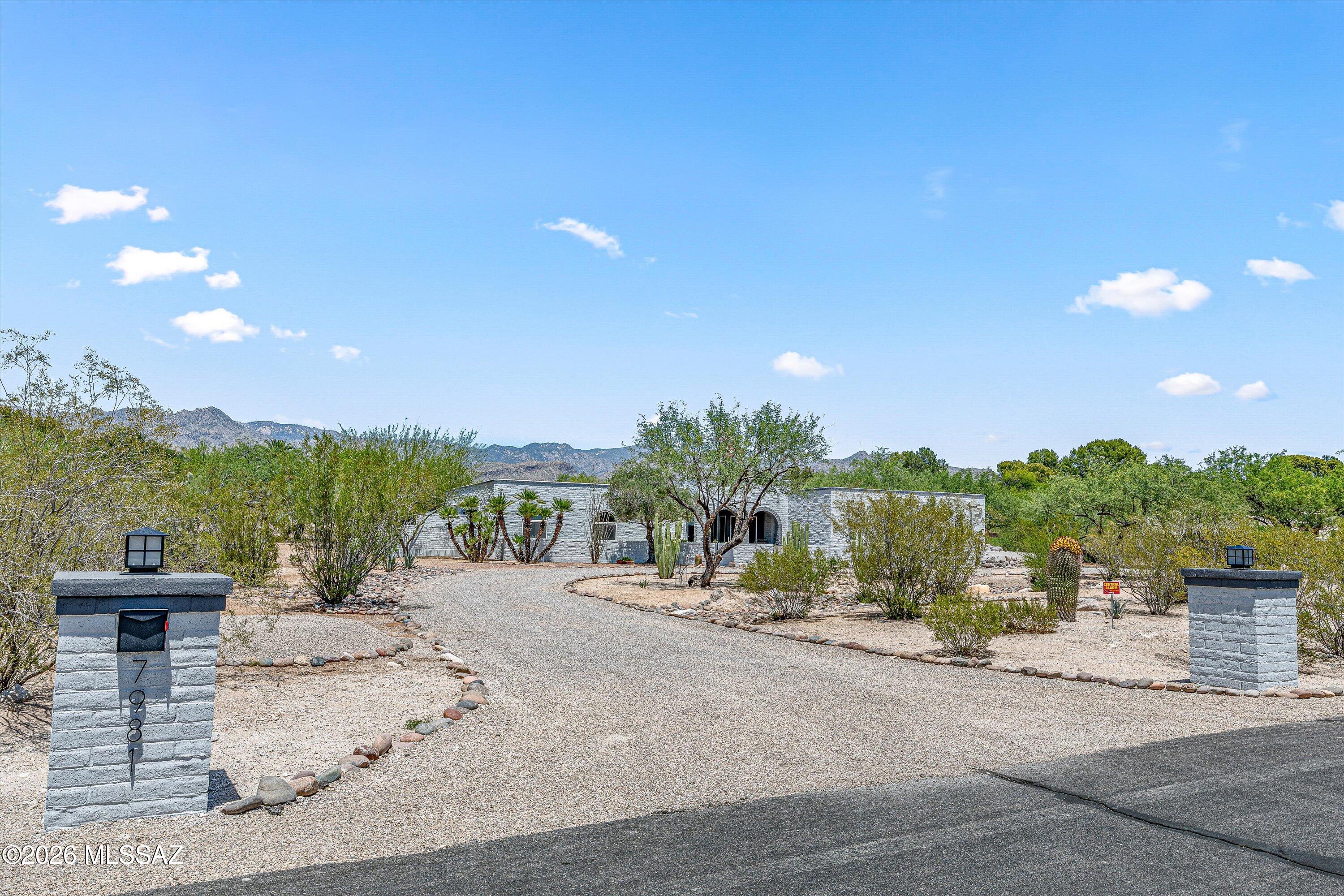 Rarely does a home come to market with this level of renovation, design, preparation, and presentation. Set on 1.3 private acres along the coveted Sabino Creek corridor, this completely reimagined 4-bedroom, 3-bath Territorial estate blends timeless Arizona architecture with refined modern luxury, creating an experience that feels both elevated and effortlessly livable.
Inside, the home immediately welcomes you with rich architectural character, exposed dark-stained beams, dramatic custom built-ins, layered designer lighting, and large-format Italian hardwood-look ceramic plank tile flowing throughout the primary living spaces. Oversized picture windows frame the surrounding desert landscape while filling the interiors with natural light and creating a seamless indoor-outdoor connection throughout the home. Every space has been thoughtfully curated to balance warmth, sophistication, and everyday livability.
At the heart of the home is a truly stunning designer kitchen created for both everyday living and elevated entertaining. Anchored by an oversized quartz island, the space features professional-grade Viking appliances, a custom vent hood, extensive custom cabinetry, designer finishes, and a picturesque mountain view window that brings the beauty of the surrounding desert indoors. The seamless open-concept design connects effortlessly to the family room and surrounding entertaining spaces, while a custom pantry hidden behind antique French doors and a built-in beverage station add both charm and functionality.
The surrounding living spaces continue the same level of thoughtful design and craftsmanship throughout. The formal living room is anchored by dramatic custom built-ins and exposed wood beams, creating a warm yet elevated gathering space filled with natural light and architectural character. The formal dining area adds sophistication with its custom coffered ceiling and elegant entertaining atmosphere, while the family room serves as a true centerpiece featuring a striking custom fireplace wall, Hickory floating shelves, antique wood mantle, and seamless access to the outdoor living spaces.
The luxurious primary retreat offers a peaceful escape with direct backyard access and a spa-inspired ensuite featuring a soaking tub, custom tile work, oversized walk-in shower, dual vanities, and designer finishes that create a true resort experience. Spacious secondary bedrooms, beautifully updated guest baths, and flexible bonus spaces provide comfort and versatility throughout the home.
Step outside into a private backyard oasis designed for year-round enjoyment. The resort-style pool and spa are surrounded by lush landscaping, expansive patio spaces, covered outdoor living areas, string lighting, and multiple entertaining spaces that create an unforgettable setting. A covered ramada, outdoor dining areas, and custom treehouse retreat further enhance the property's unique charm and lifestyle appeal.
From the moment you arrive, the home makes a statement. The classic slump block exterior has been professionally refinished in a sophisticated soft grey-white palette, complemented by dramatic double arches, curated desert landscaping, and an expansive newly added 40x28 concrete parking area. Every detail has been intentionally considered, delivering a property that feels polished, current, and completely move-in ready.
Set on an expansive homesite surrounded by mature desert vegetation and stunning mountain views, this exceptional property offers a rare combination of privacy, space, architectural character, and resort-style living.
Situated along the coveted Sabino Creek corridor, the home offers direct access to nearby jogging, cycling, and riding trails while remaining just minutes from Sabino Canyon Recreation Area, dining, shopping, and everyday conveniences. Voluntary HOA.