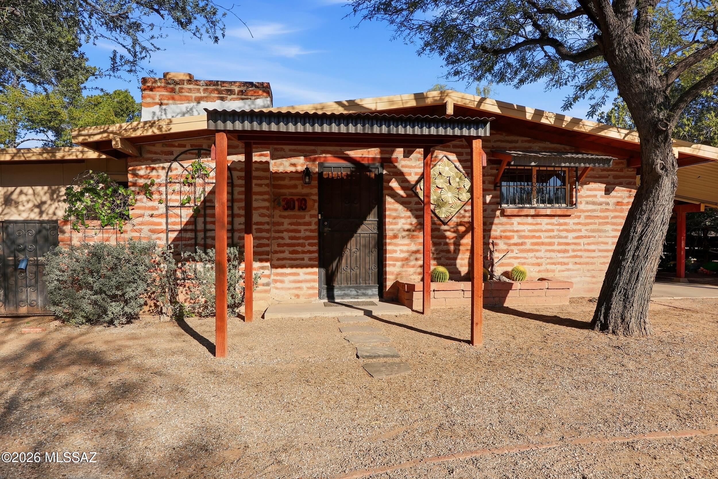 This charming adobe home sits in a beautiful, well established Tucson neighborhood just 1.5 miles north of the University of Arizona and minutes from Banner and TMC hospitals, downtown, shopping, and great restaurants. Set on a generous 8,400 SF lot, the property features mature front landscaping and a private, peaceful backyard oasis. Inside, the Arizona Room off the living room adds valuable extra space, complementing the warm character of the 2 bedroom, 1 bath layout. A cozy wood burning fireplace anchors the spacious living room, while the retro kitchen and tongue and groove ceilings throughout enhance the home's inviting charm. A true treasure in the heart of Tucson.