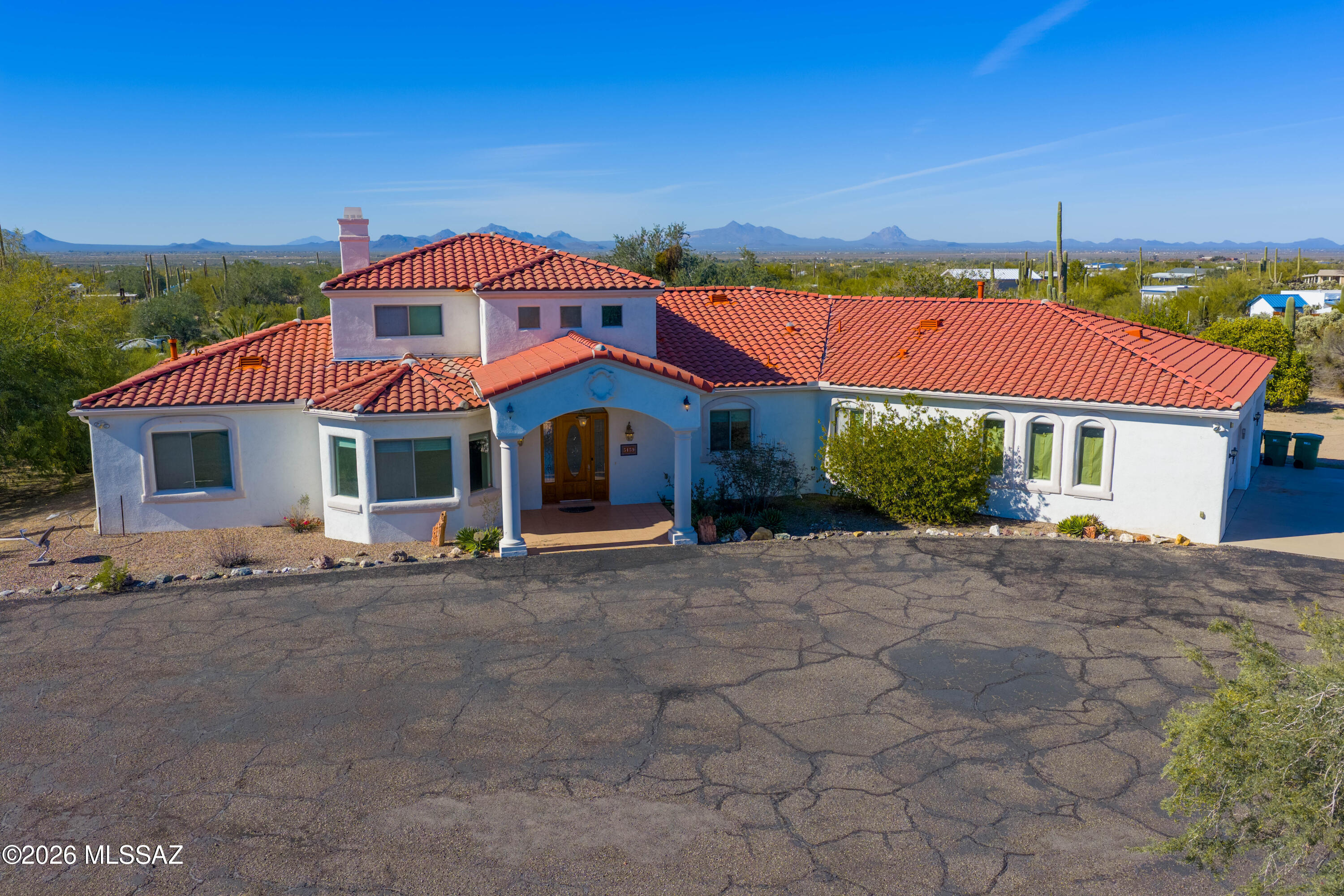 Come experience this beautiful 3-bedroom plus den, 2.5-bath home with a spacious loft, located in the desirable Picture Rocks area of Tucson. Situated on over 4 acres, this property offers exceptional privacy along with an orange grove, paved driveway, and a 3-car attached garage. A true standout is the impressive 60' x 35'' detached shop featuring three bay door openings, including space for an RV—ideal for projects, hobbies, or a small business. This custom home features tile flooring throughout all main walkways and high-traffic areas. The gourmet kitchen is nicely updated with granite countertops, abundant custom cabinetry, an island with sit-up breakfast bar, generous prep space, and a gas stove—perfect for both everyday living and entertaining. The front office provides an ideal work-from-home setup with stunning mountain views.
The oversized, split primary suite offers a private retreat with its own exterior exit. The en-suite bathroom includes a private water closet, dual sinks, soaking tub, walk-in snail shower, and a large walk-in closet. Two additional oversized bedrooms share an updated hall bathroom with dual sinks and a separate tiled shower and tub; one bedroom also features a walk-in closet and direct access to the back patio. An expansive loft provides flexible space for family gatherings, recreation, or a play area. A convenient powder room is located near the interior laundry room, which includes ample workspace and storage. One bay of the attached 3-car garage is cooled, adding extra versatility. Step outside to enjoy Arizona living at its best from the back patio, complete with desert views and a built-in BBQ. Additional features include a private well, new HVAC units, newer roof (2024), a backup generator, abundant storage, and exceptional privacy throughout the property. This truly unique home is a must-see.